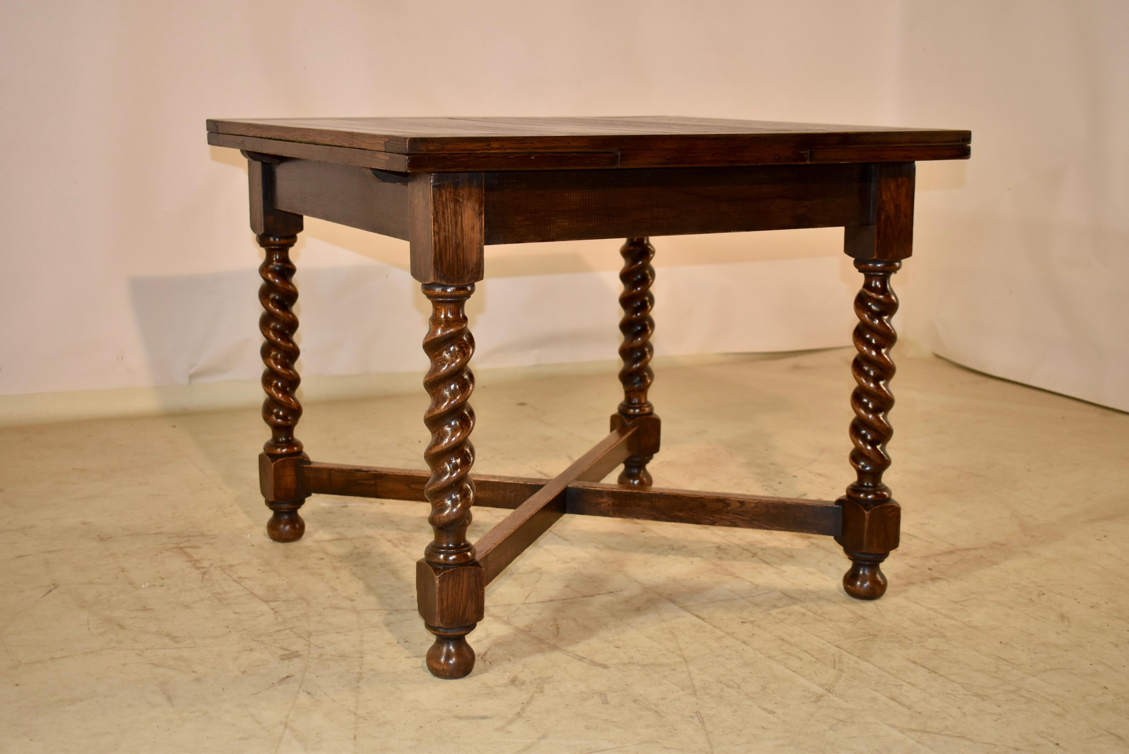 Circa 1900 Edwardian oak table with two draw leaves from England.  The top and leaves are hand paneled, and when both leaves are extended, the top measures 60 inches in length.  The top follows down to a simple apron and is supported on aha turned