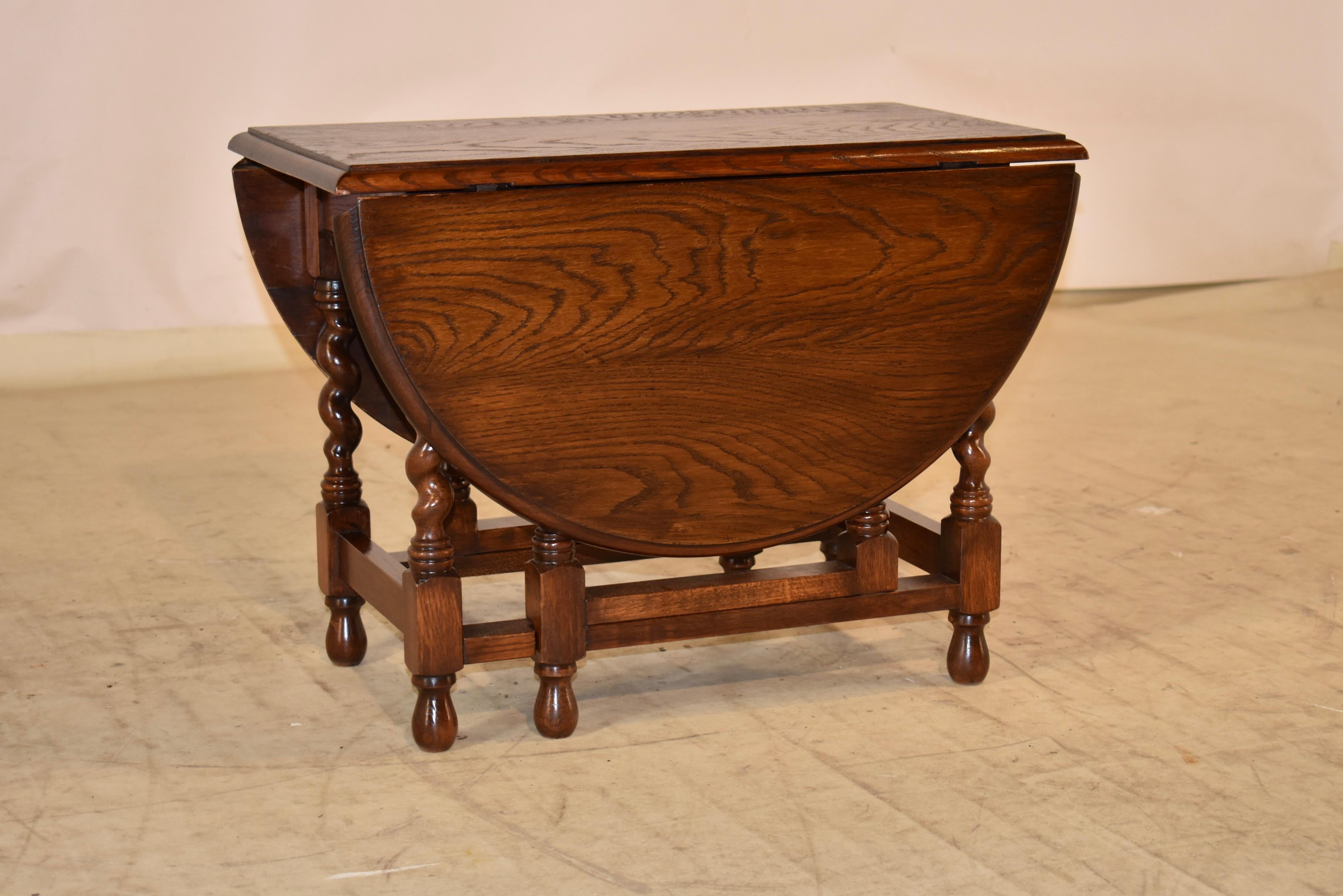 Edwardian oak coffee or cocktail table with two drop leaves.  The table when open measures 35.13 long x 24 wide x 17.75 high.  The top has a lovely graining and a beveled edge, supported on hand turned barley twist legs.  The legs are joined by