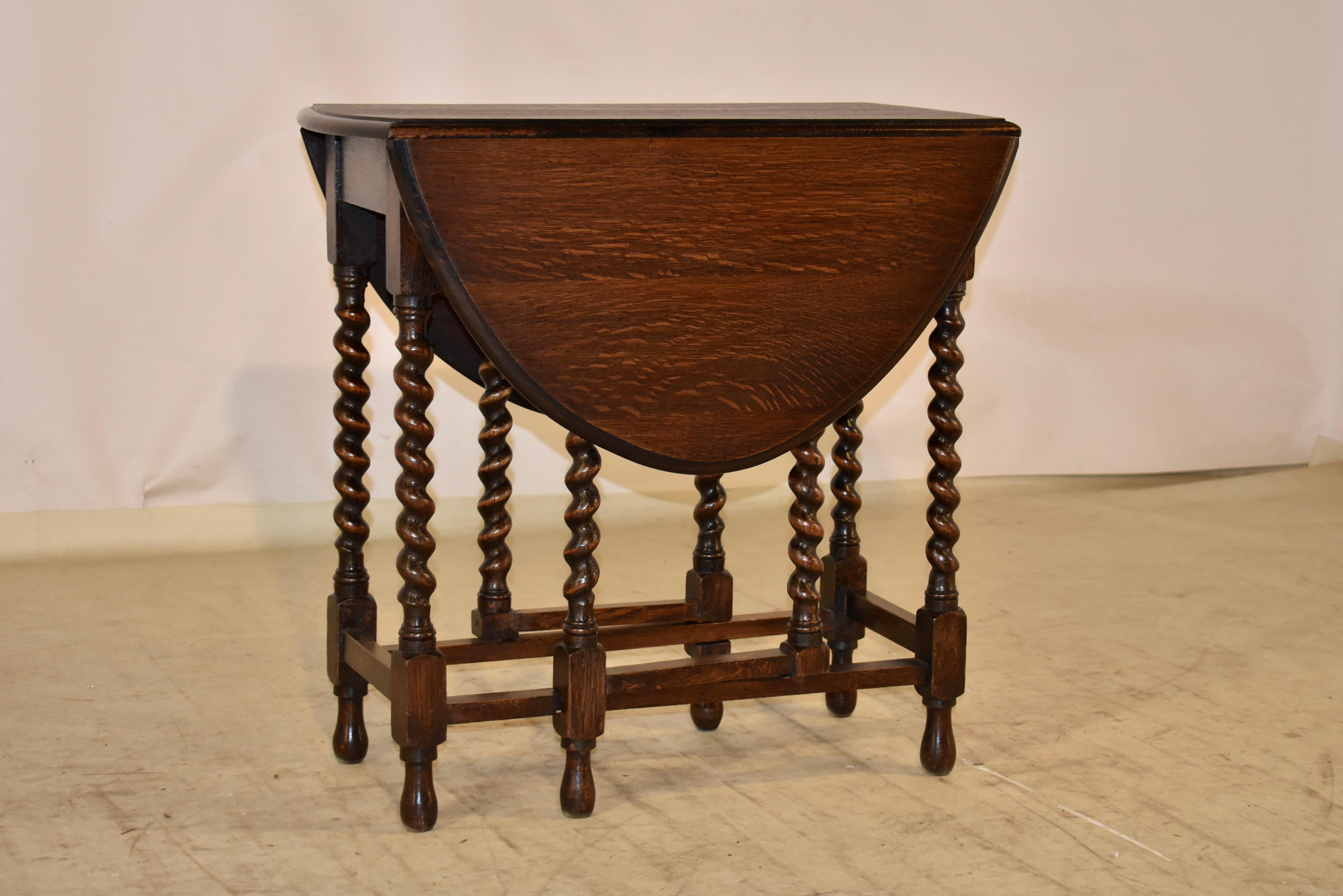 Period Edwardian gate leg table from England.  The top has a beveled edge , following down to a simple apron and supported on hand turned barely twist legs and gates.  The legs are joined by simple stretchers, and raised on hand turned feet.  The