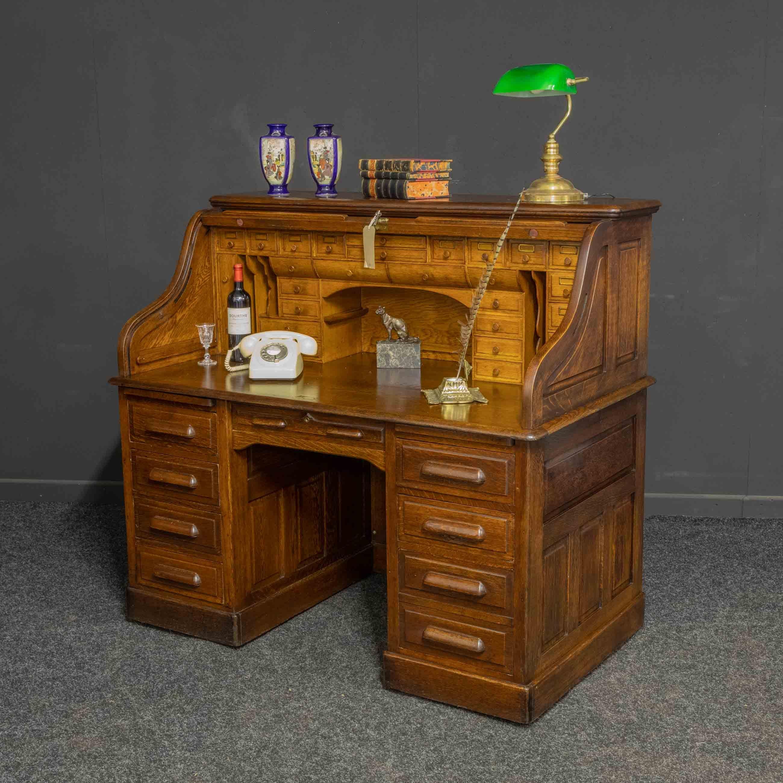 A fine quality oak roll top desk from the Edwardian period. As with most quality roll top desks all the exterior panels are fielded (bevelled) and can look and be used off the wall. All the pedestal drawers lock automatically when the roll is down