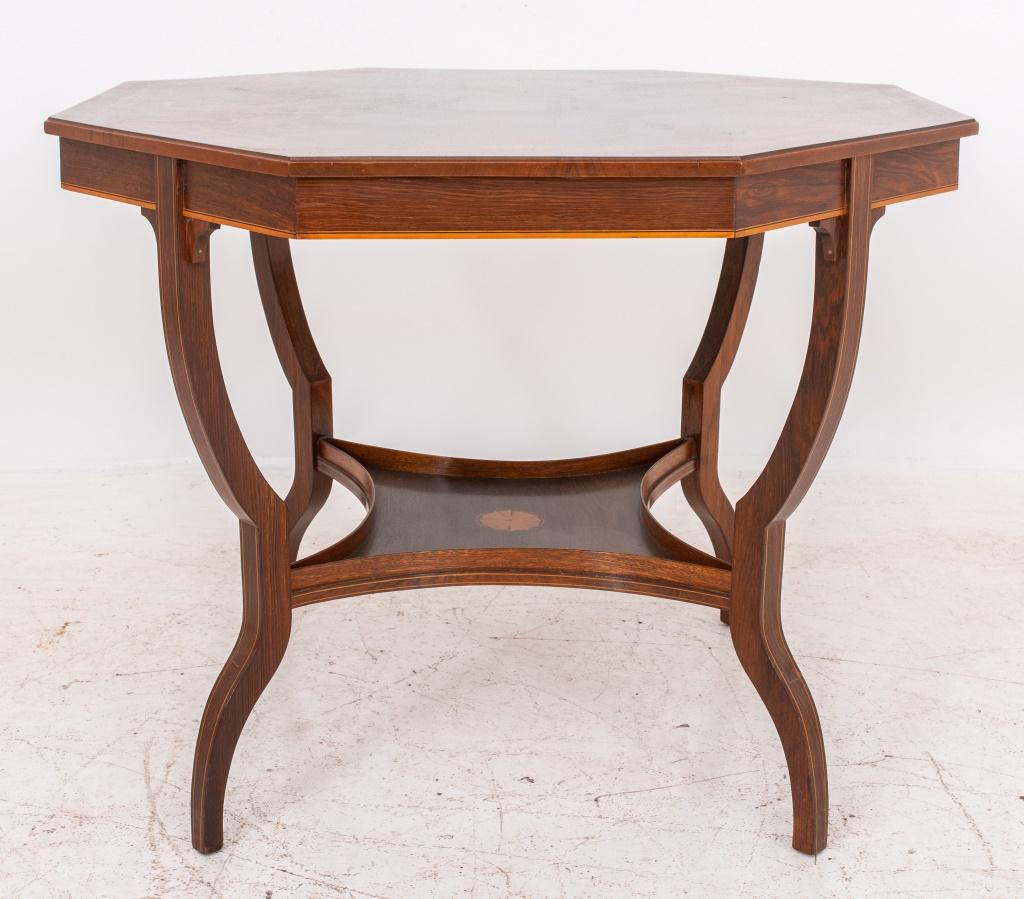 Edwardian octagonal pear- and satinwood- inlaid rosewood lamp table, circa 1905, the edges decorated with stringing and inlaid anthemiae, supported by four legs conjoined by a concave square-form lower tier, the canted legs terminating in