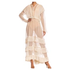 Robe de thé édouardienne blanc cassé en voile de coton biologique et dentelle à manches longues et volants