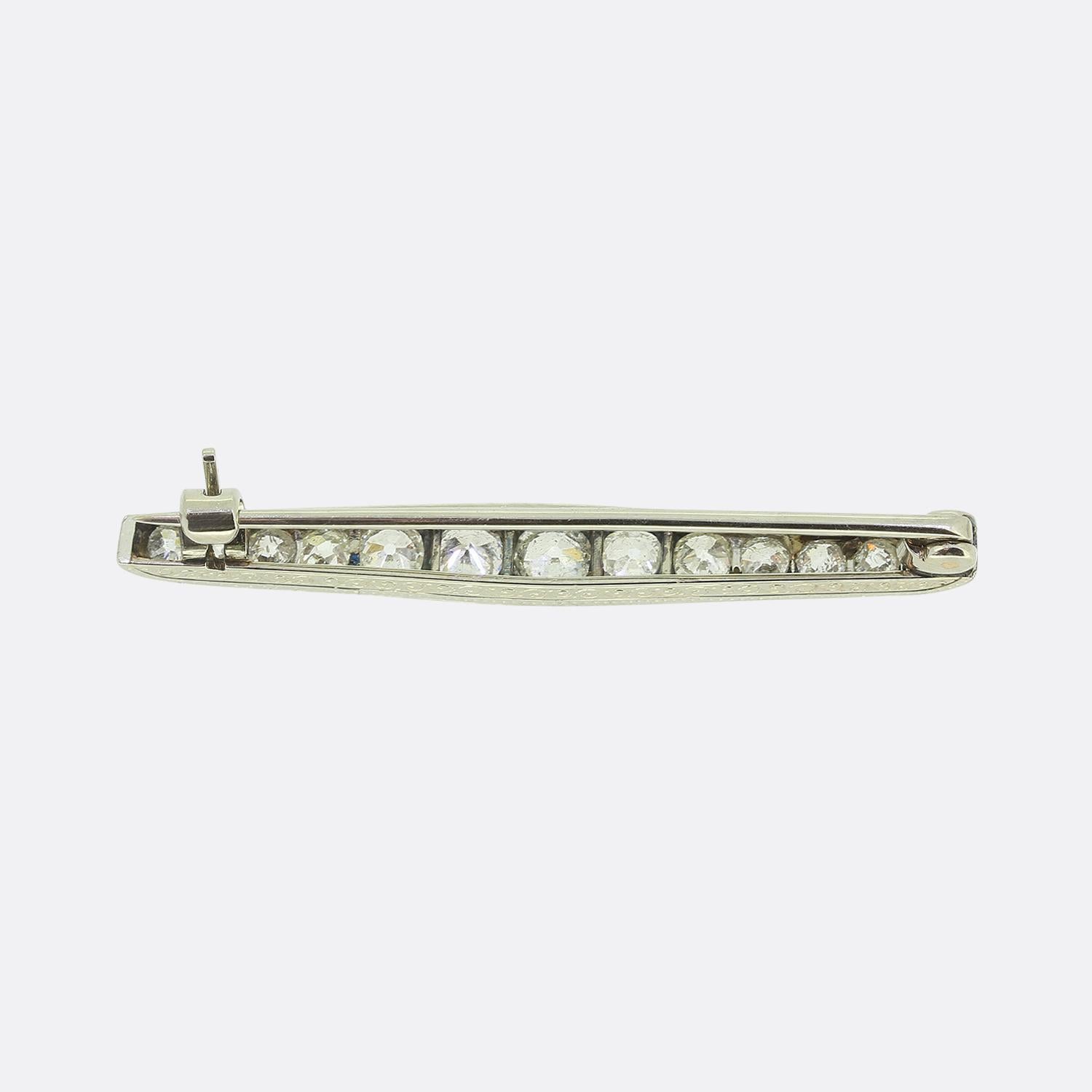 Here we have a refined brooch crafted in platinum and adorned with a series of old European cut diamonds. These white diamonds are elegantly aligned, creating a seamless flow of brilliance across the piece. Interspersed among them are old mine cut