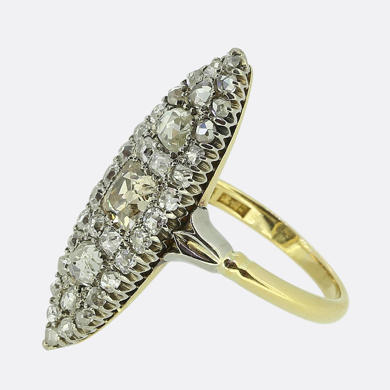 Hier haben wir einen wunderschönen Navette-Ring, der eine auffällige Kombination von Diamanten zeigt. In der Mitte des Gesichts liegt ein antiker quadratischer Diamant im Kissenschliff. Dieser einzigartige Hauptstein hat einen hellbraunen Farbton -