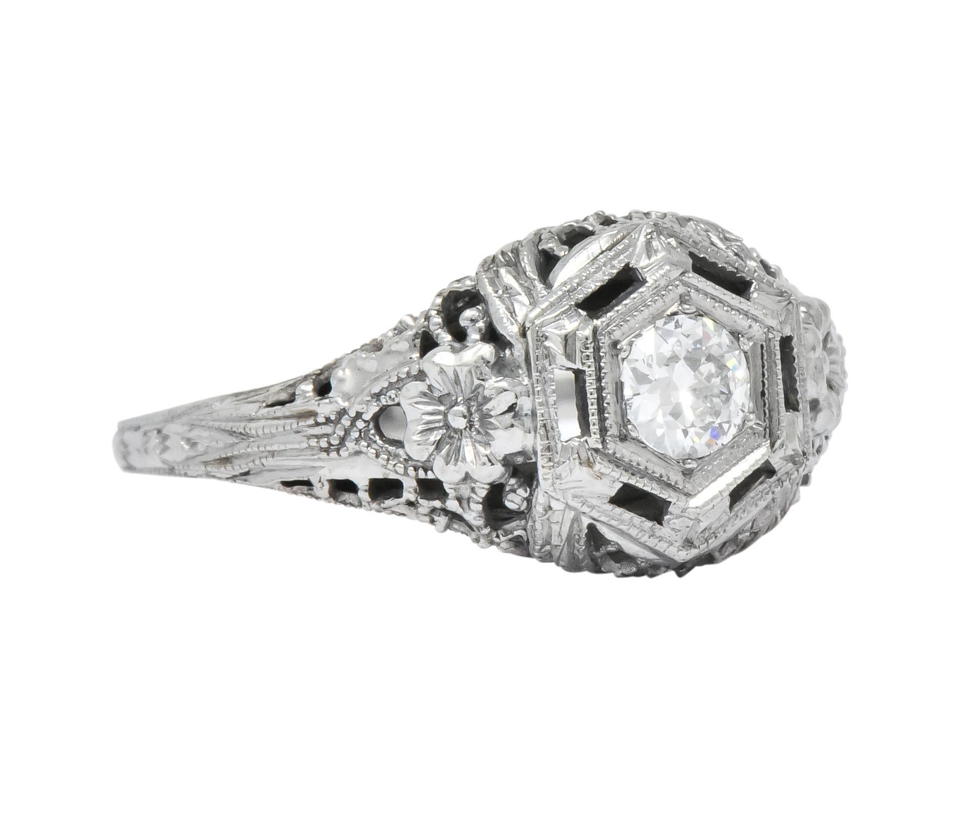 Centering an old European cut diamond weighing approximately 0.20 carat, H color and VS clarity

Bead set in a hexagonal pierced mount

With floral and millegrain details and fully engraved shank

Stamped 18K

Ring Size: 5 3/4 & Sizable (please
