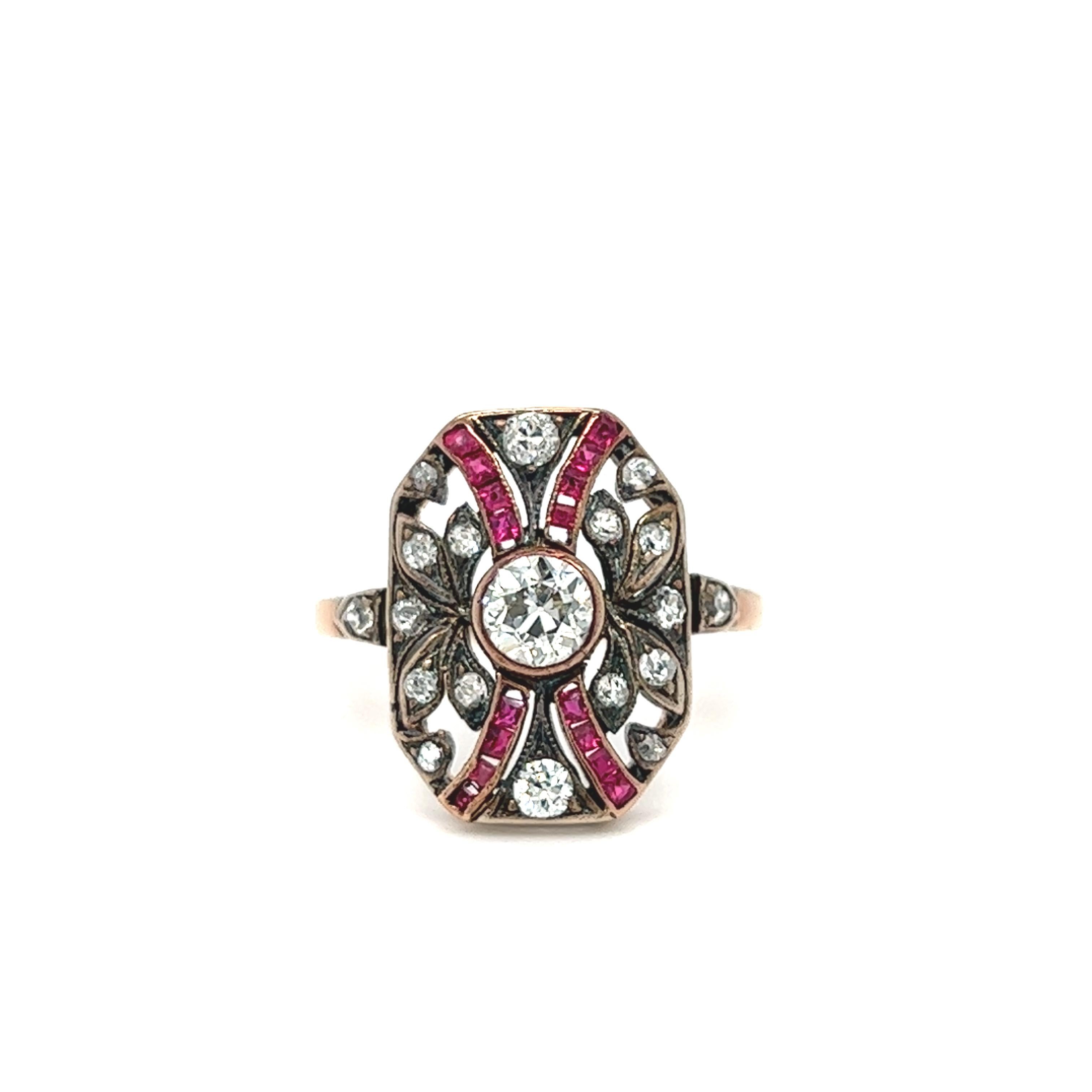 Finely detailed antique Edwardian ring (circa 1900s to 1910s) crafted in rose gold. This rare find Edwardian era shield ring features millgrain set and an openwork ruby and diamond set plaque. Centrally mounted is an old cut diamond estimated 0.40