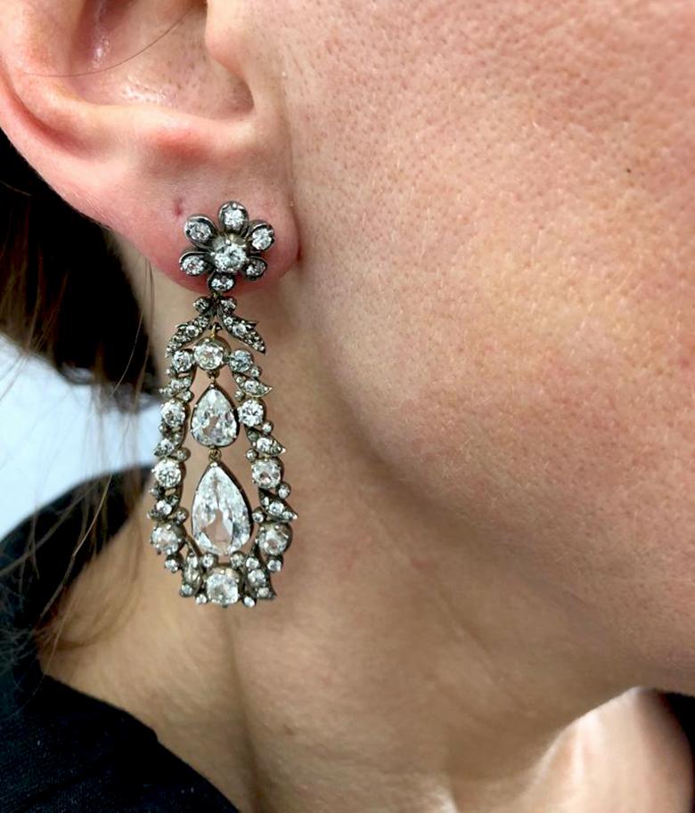 Edwardian Old European-Cut Diamond Drop Earrings in Silver and Gold.
A magnificent pair of drop earrings dating from the Edwardian era which have been authentically patinated over time. The top floret features round diamonds of pinched collet