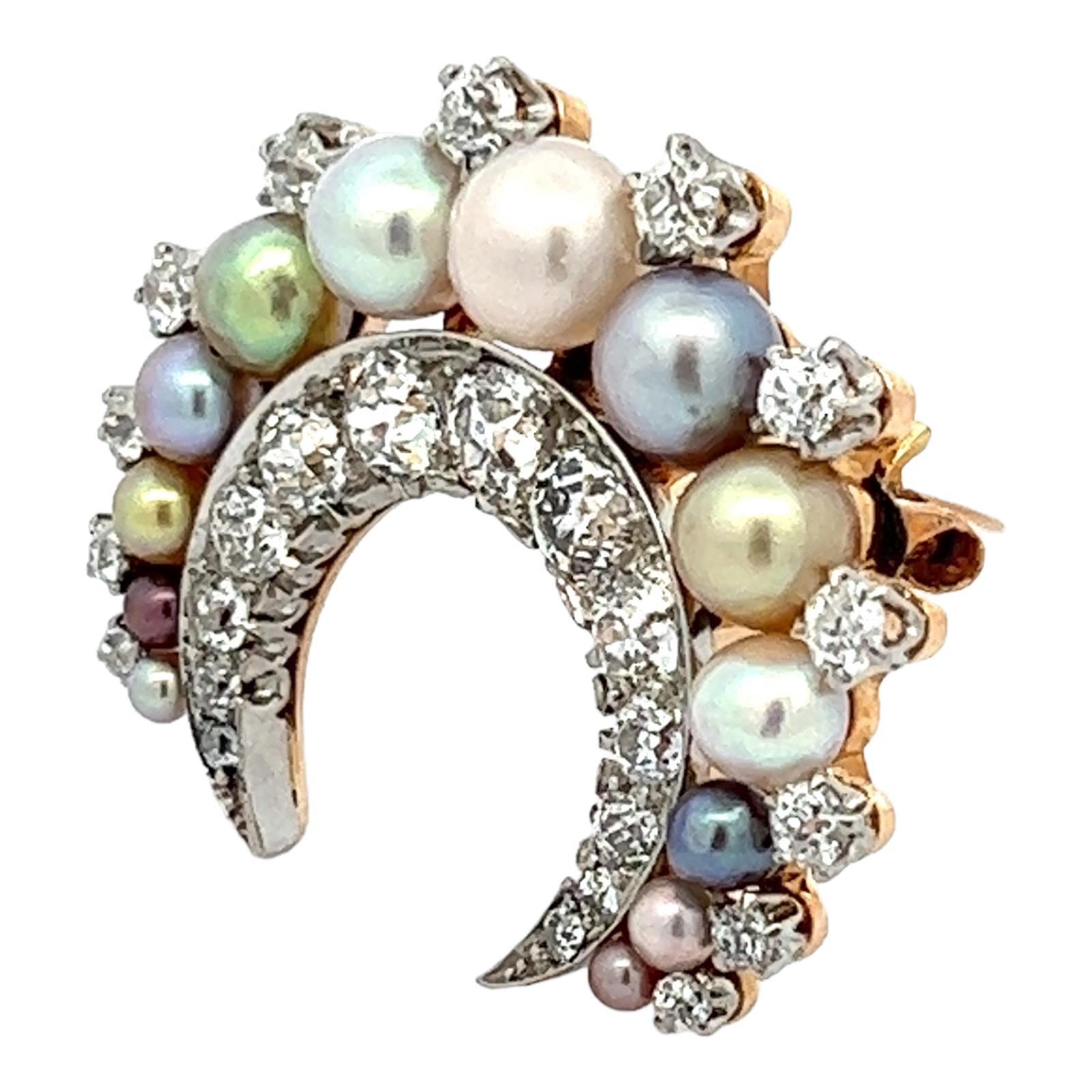 An original Edwardian diamond pearl crescent brooch handcrafted in platinum and 18 karat yellow gold. The brooch features multi-color graduated pearls and 25 Old Mine Cut Diamonds weighing approximately 2.00 carat total weight. The diamonds are