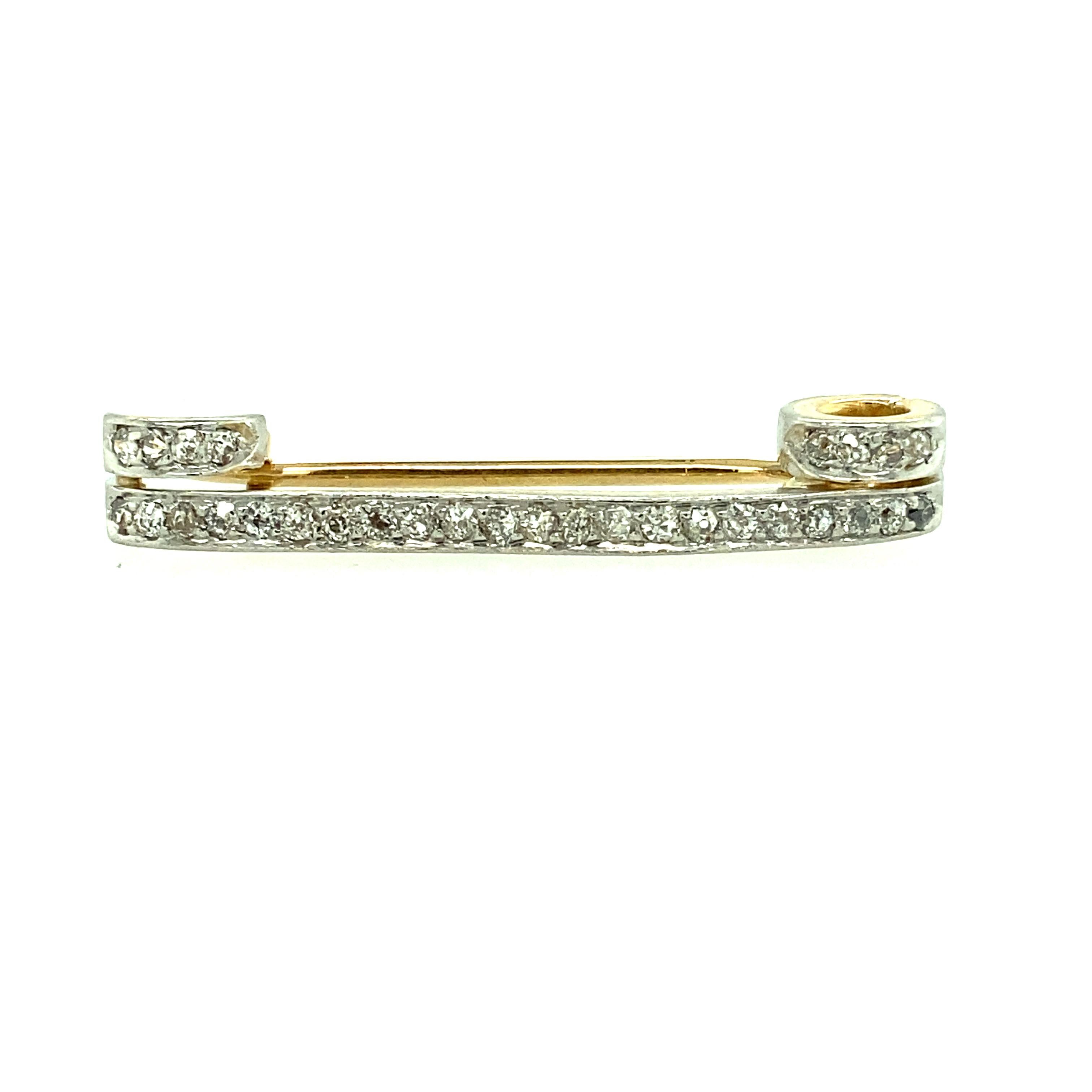 One platinum and 14 karat yellow gold estate pin set with thirty Old Mine cut diamonds, with J/K color and SI clarity. The pin measures 1.5 inches wide and is complete with a traditional pin closure.  