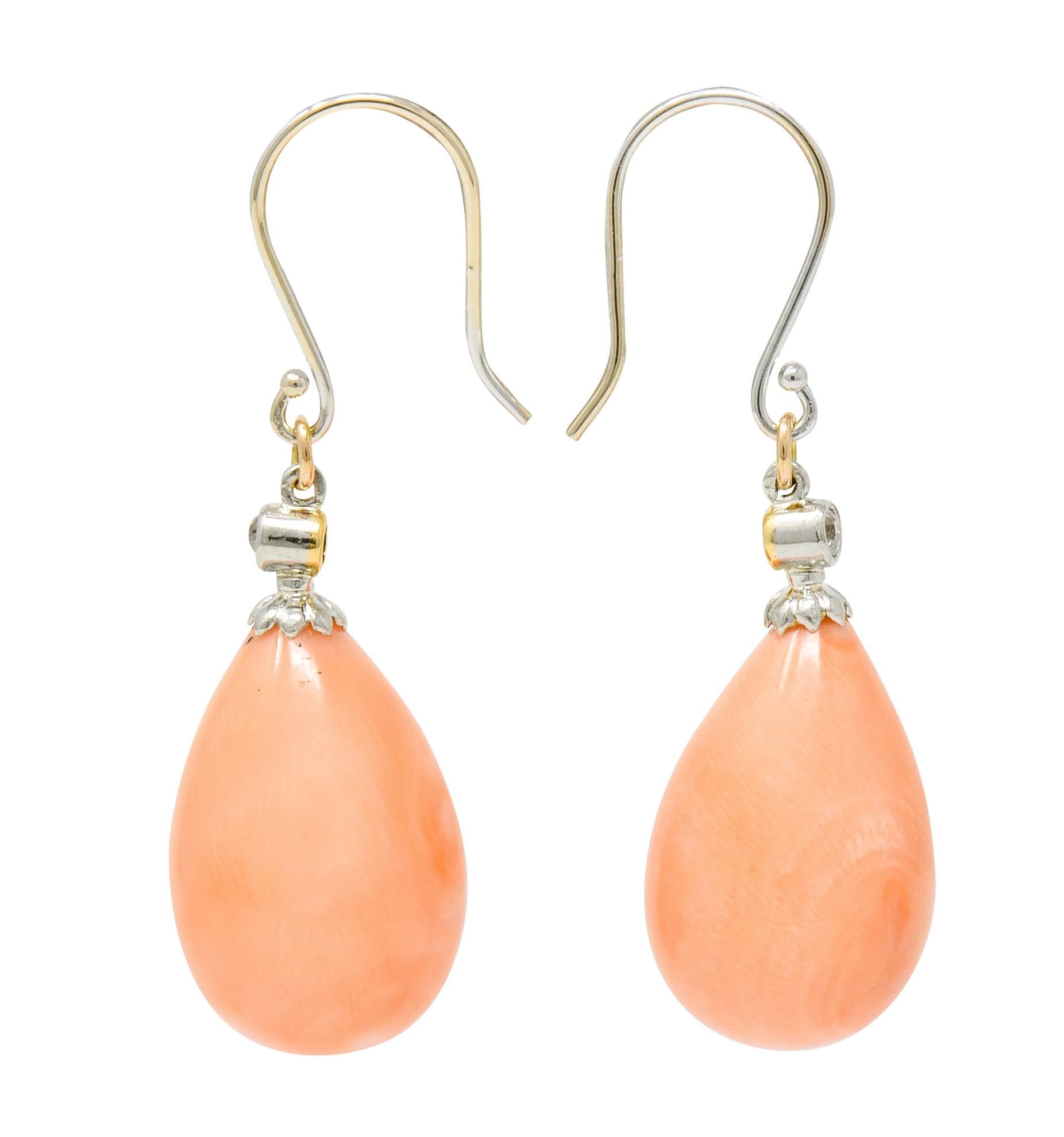 Earrings feature a bezel set old mine cut diamond as surmount with a scalloped cap

Total diamond weight is approximately 0.08 carat, eye-clean and white

Suspending substantial coral drops, very well-matched pastel orangey-pink in color with