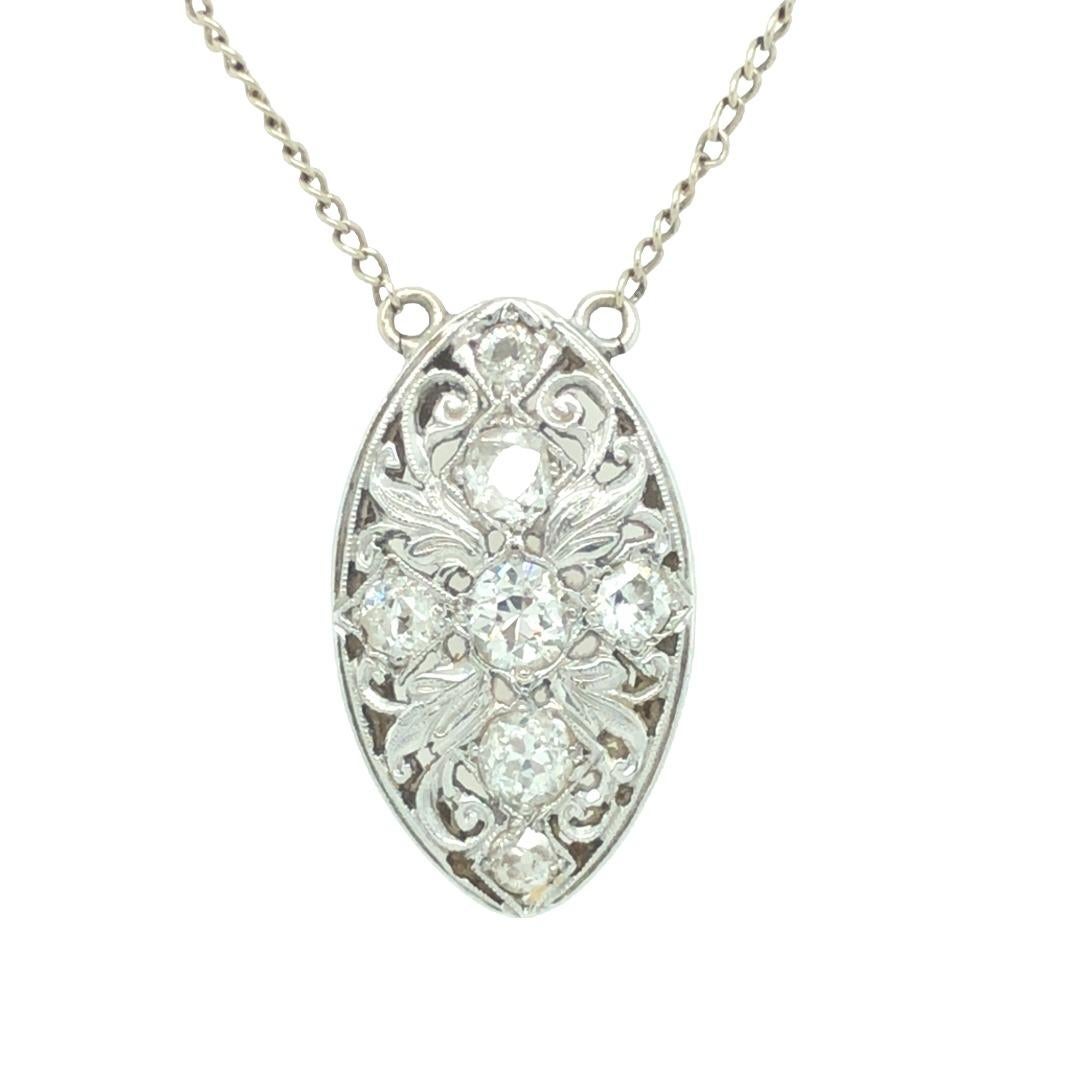 Finely detailed Edwardian navette shaped pendant crafted in 14K white gold. Surrounding the old mine cut diamonds are scrolls of openwork filligree and Intricate foliate detail. Seven near colorless old mine cut diamonds weigh approximately 1 carat
