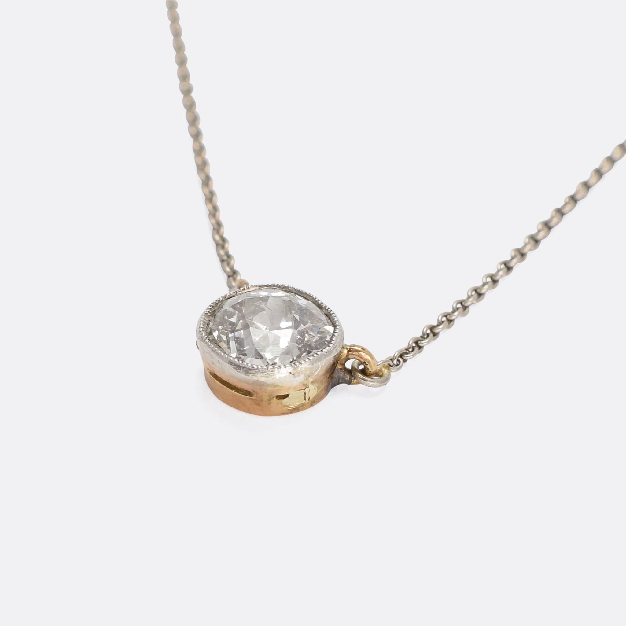 A beautiful antique diamond pendant dating from the early 20th Century, circa 1910. Very much modelled in the Edwardian style, the one carat old mine cut stone rests in a millegrain collet setting, with a 15k gold back and mounted on an 18 inche