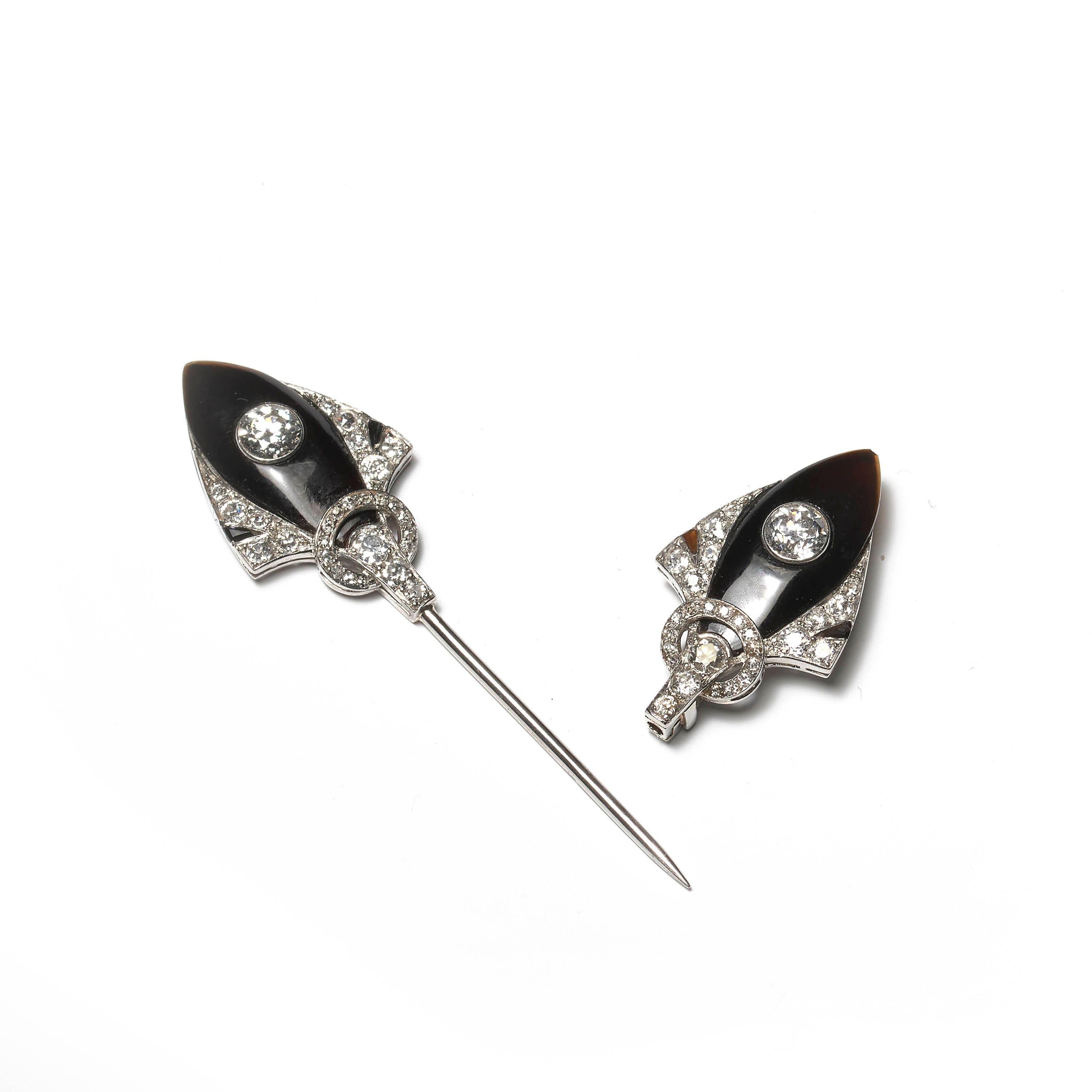 An antique Belle Epoque jabot pin, comprised of two shield-shaped sections set with polished black onyx and transitional-cut diamonds, all mounted in platinum, with possible French hallmarks. The total estimated diamond weight is 2.50 carats. Circa