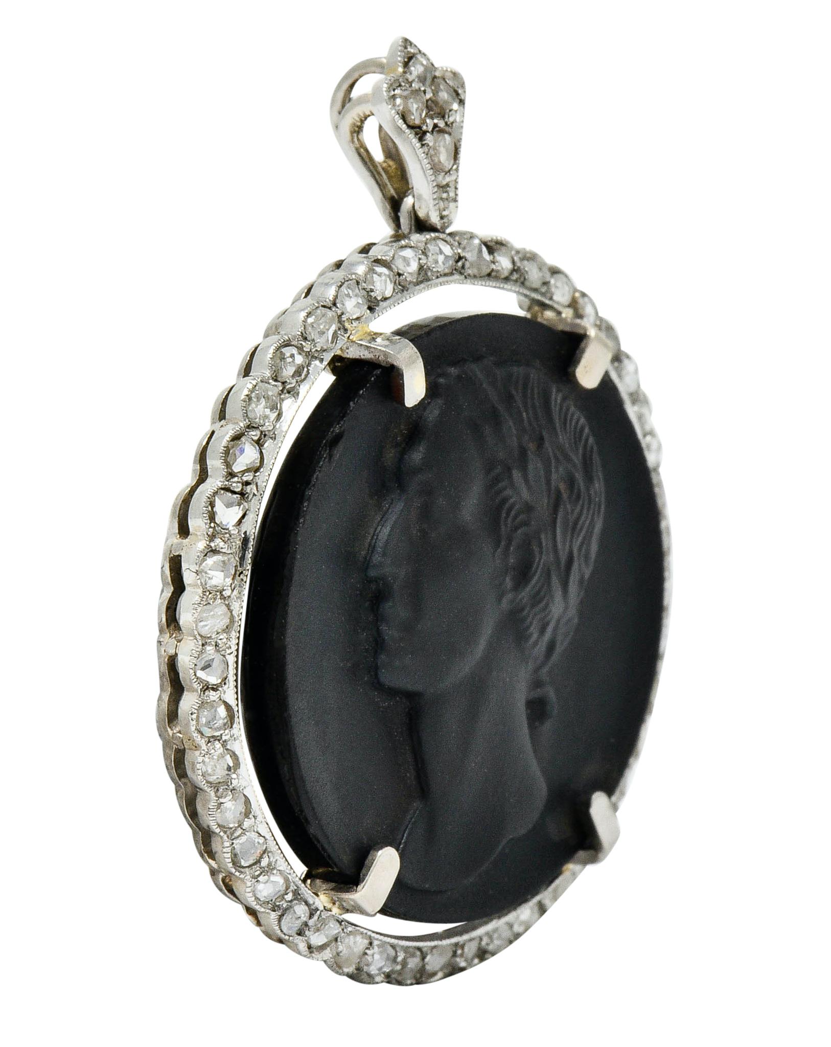 Centering a 22.0 mm circular tablet of matte finished onyx

Intricately carved to depict a cameo bust of Julius Caesar adorned in laurels

Surrounded by a scalloped platinum border accented by rose cut diamonds

Weighing in total approximately 0.65