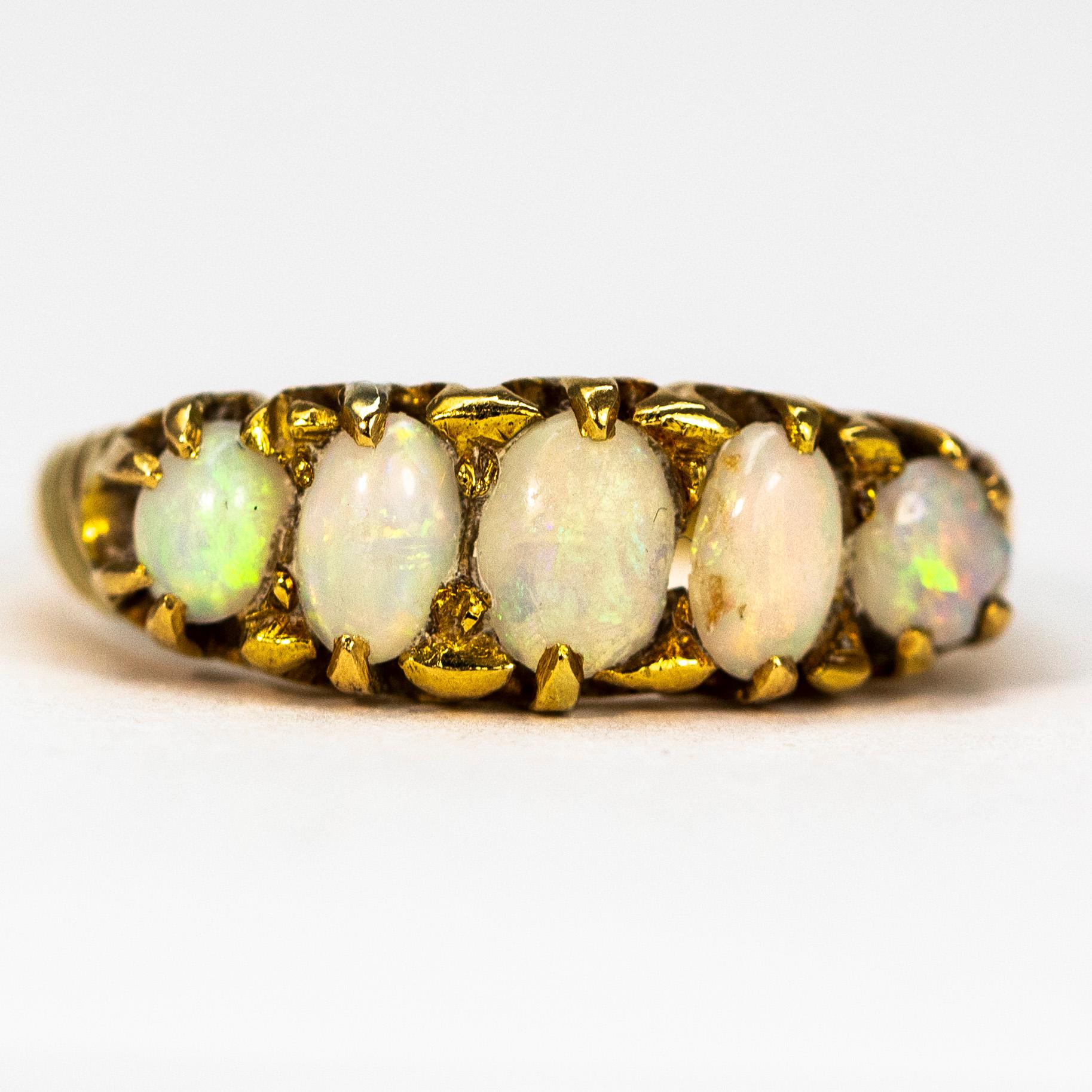 This gorgeous five stone ring holds five shimmering opals which reflect so many colours as the light hits them. The stones are set flush within the band  in simple claw settings. Made in Chester, England and modelled in 18ct gold.

Ring Size: M or 6