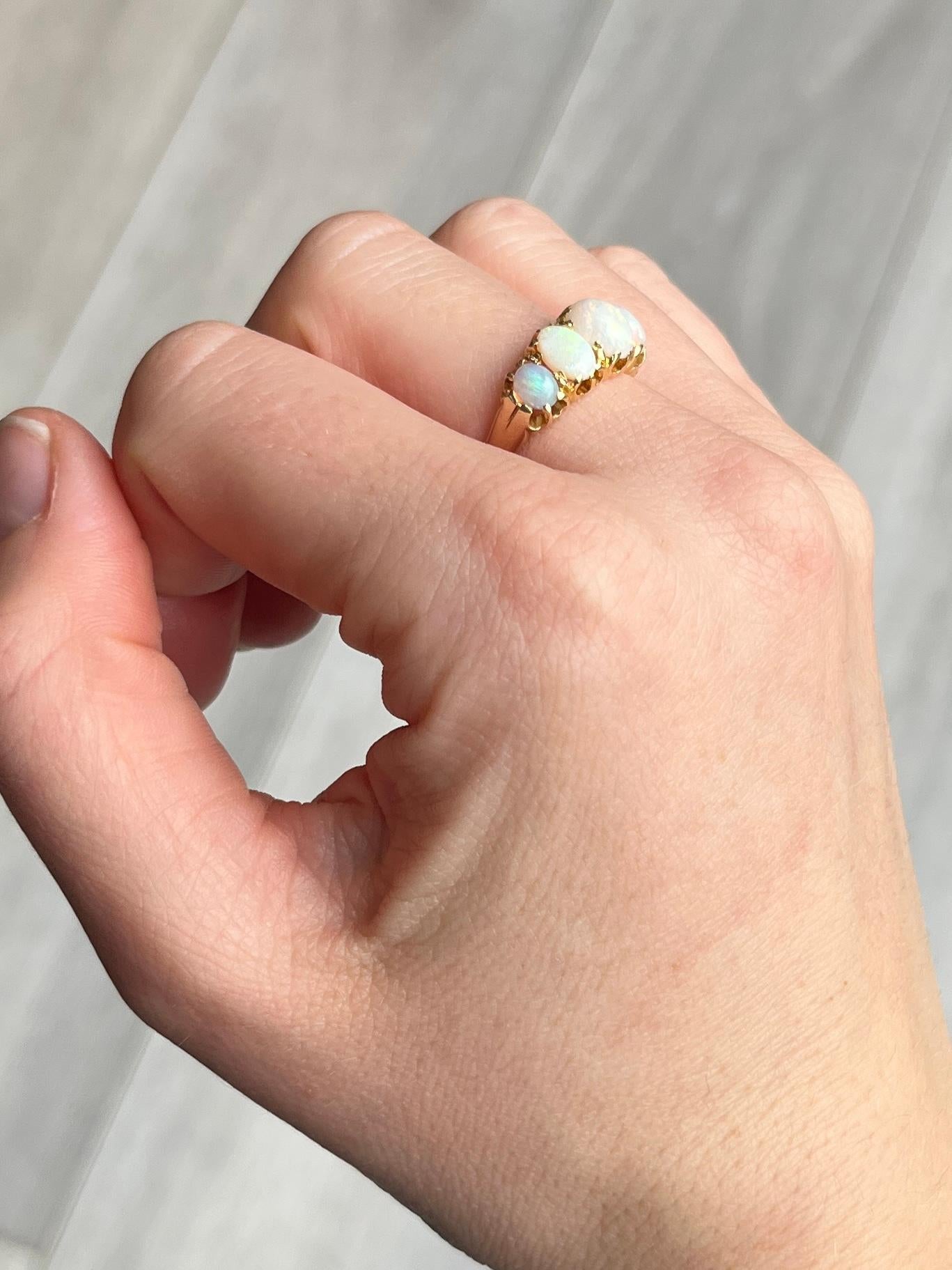 The opals in this ring are gorgeous and throw some great colours. They are set upon a simple gallery in 18ct gold claw settings. Hallmarked Birmingham 1900. 

Ring Size: L 1/2 or 6 
Band Width: 8mm 
Height Off Finger: 6mm

Weight: 3.5g