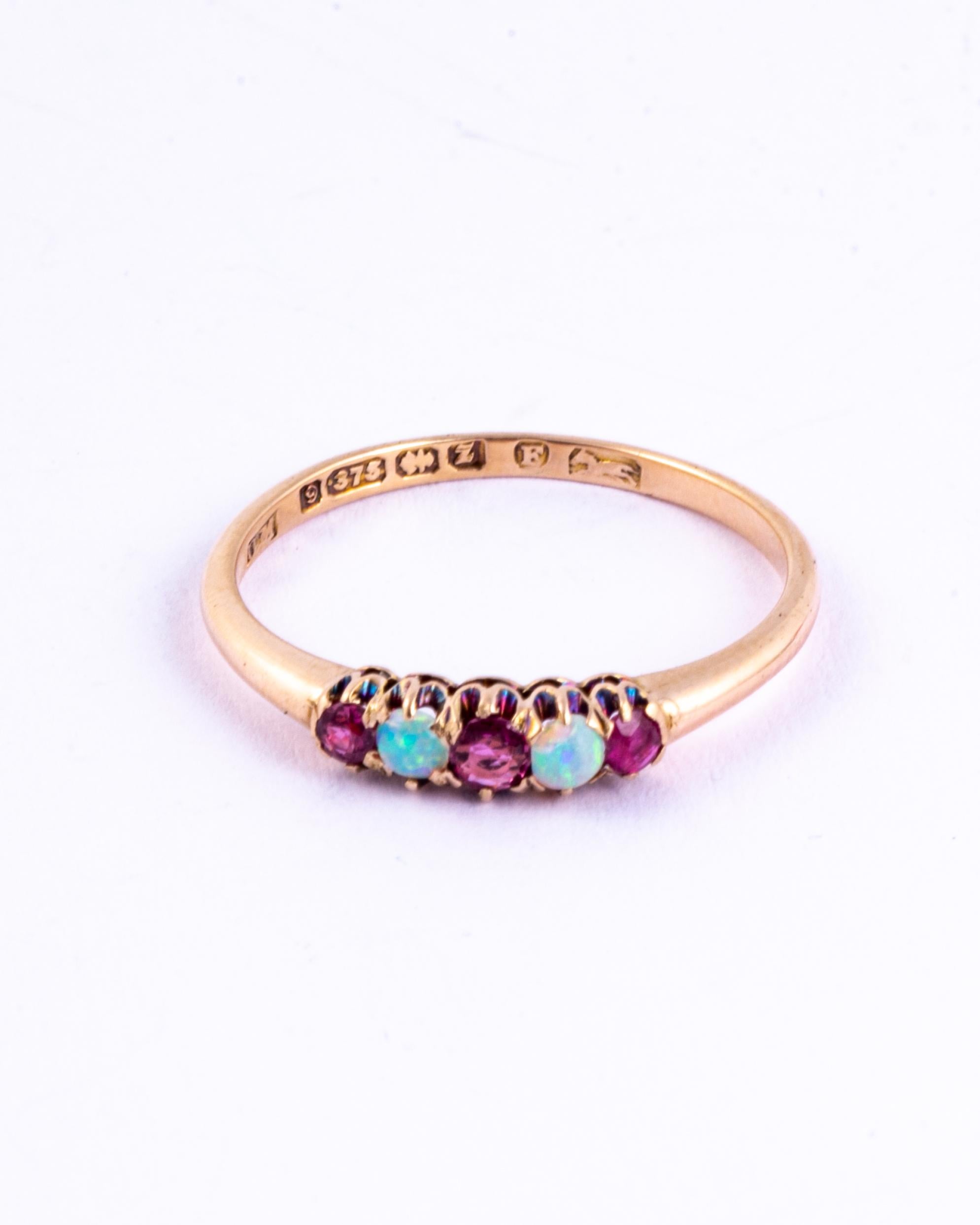 This stunning glossy gold band holds two wonderfully coloured 7pt opals which reflect the light beautifully. On each side of the opals there sits a ruby, these total 20pts. Modelled in 9ct gold and made in Birmingham, England. 

Ring Size: N or 6