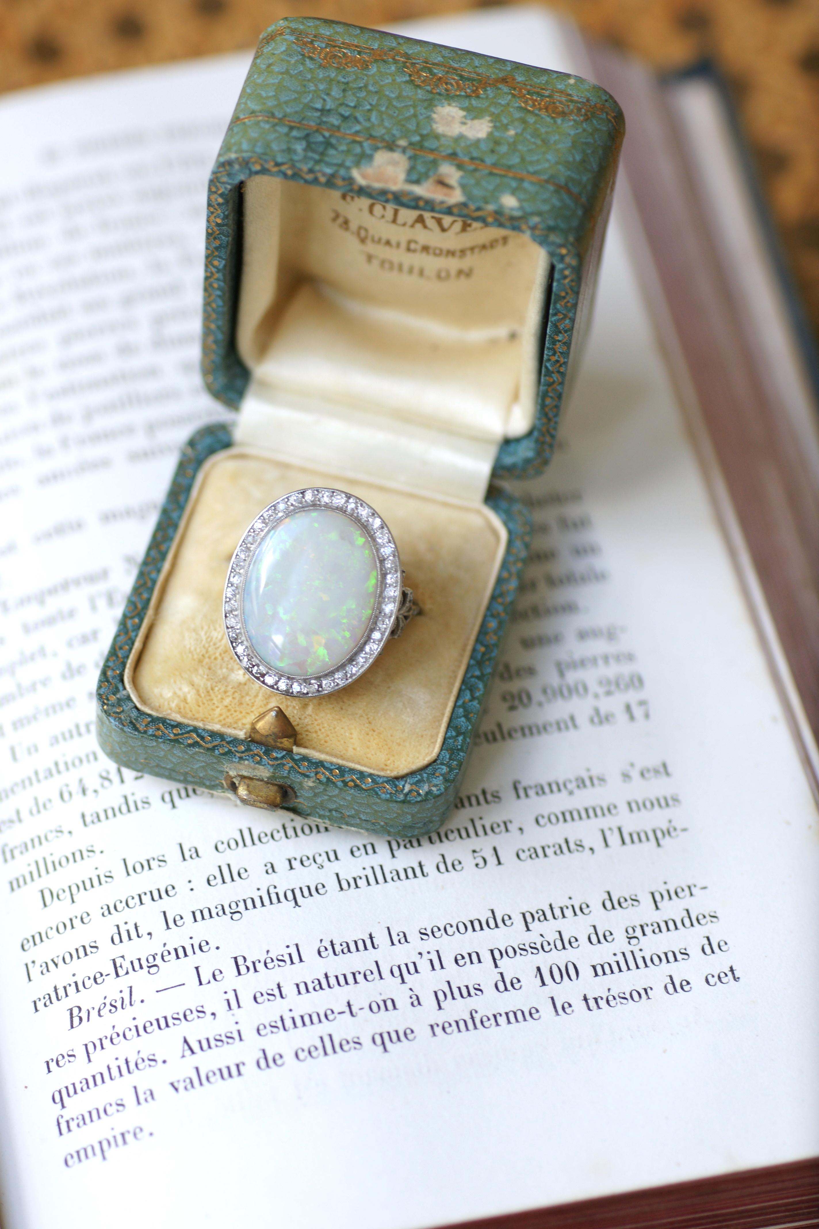 Cluster ring composed of a delicate platinum mounting (hallmark: mascaron), which is adorned in its center with a superb Australian opal cabochon weighing approximately 6.70 Cts, in a surround of 8x8 cut diamonds.
Total weight of diamonds estimated