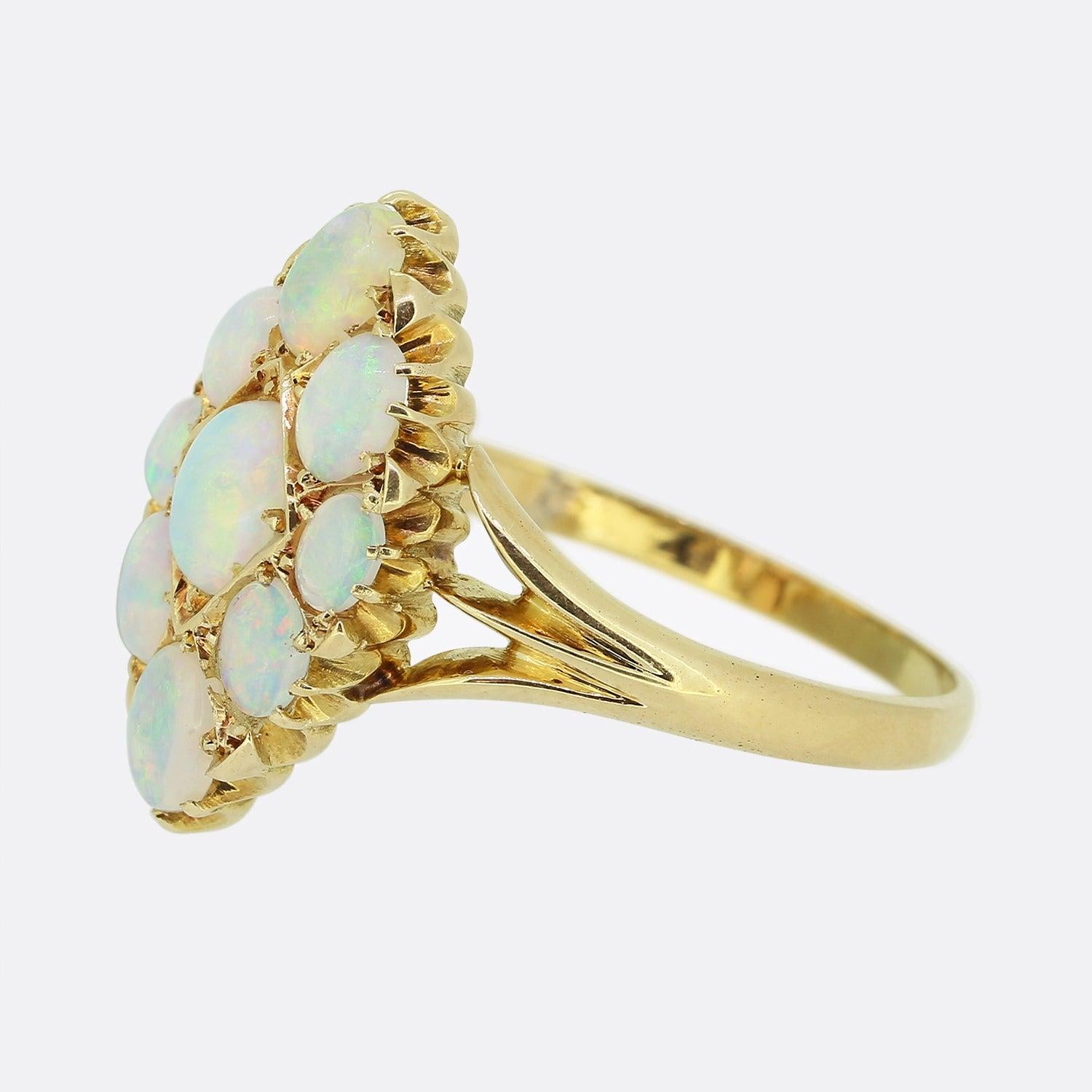 Here we have a stunning antique opal navette ring dating back to the Edwardian period. A cluster of nine oval shaped white opals possessing a magical iridescence, dominate the boat shaped face in individual clawed settings. The piece is then
