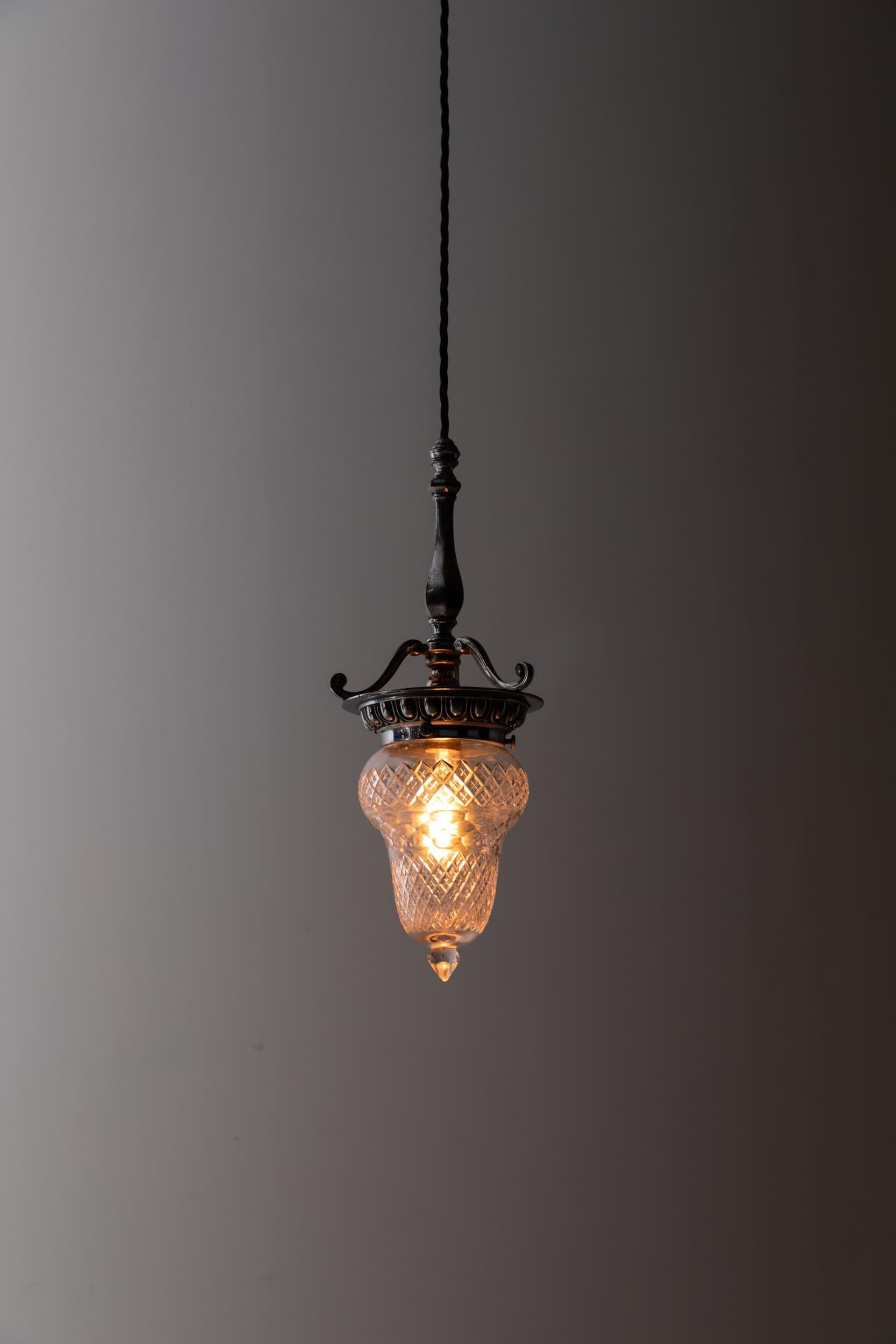 A stunning cut glass pendant light with ornate cast gallery. c.1900

Of beautiful design and form, teardrop shaped hand-cut glass shade with bottom finial. High quality nickel plated cast brass gallery with central stem above egg and dart detailed