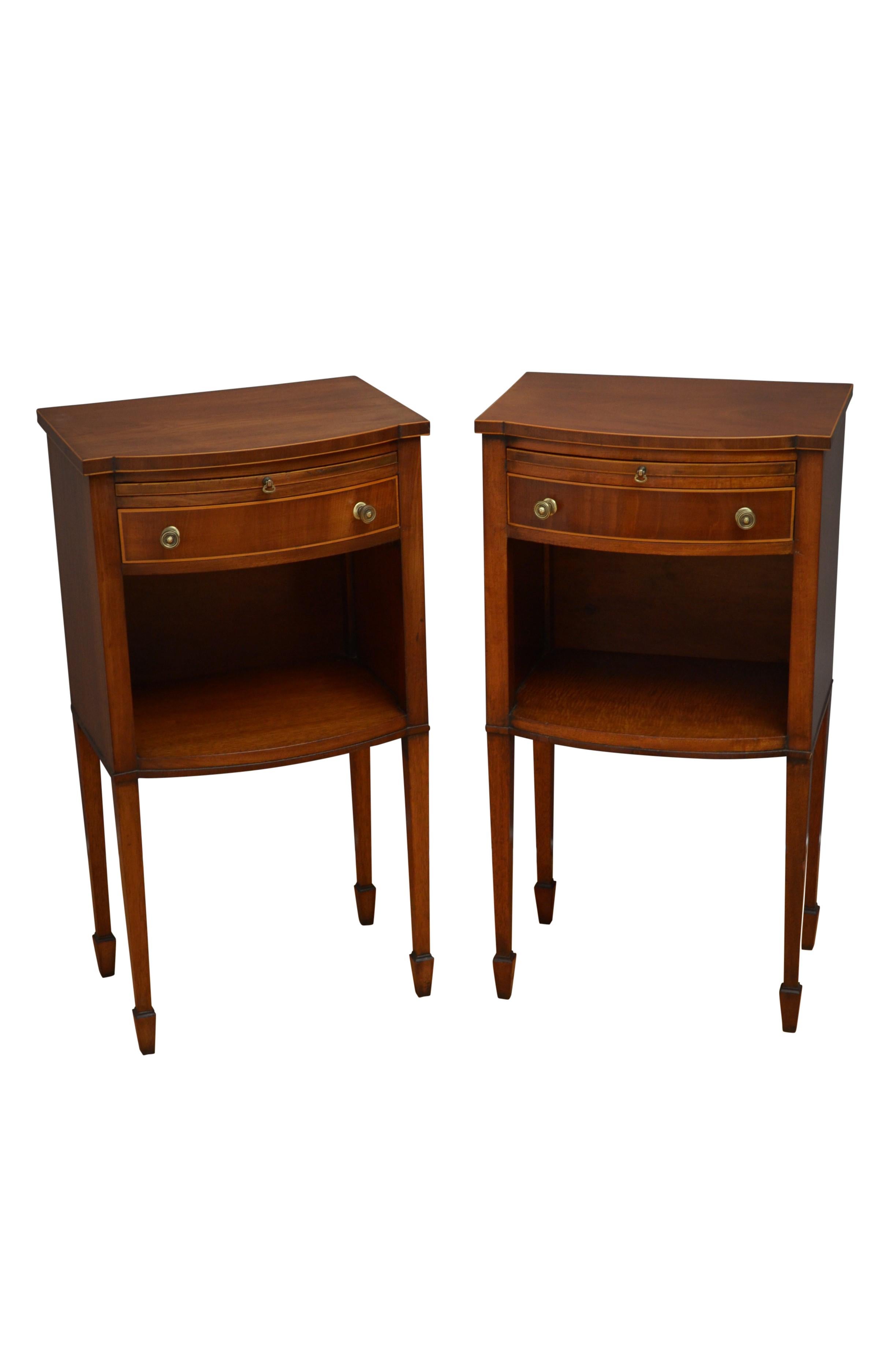 K0573 Antique pair of bedside cabinets, each cabinet having figured mahogany top above a slider, string inlaid drawer and open space, standing on slender , tapered legs terminating in spade feet. This antique pair of bedside cabinets is in home
