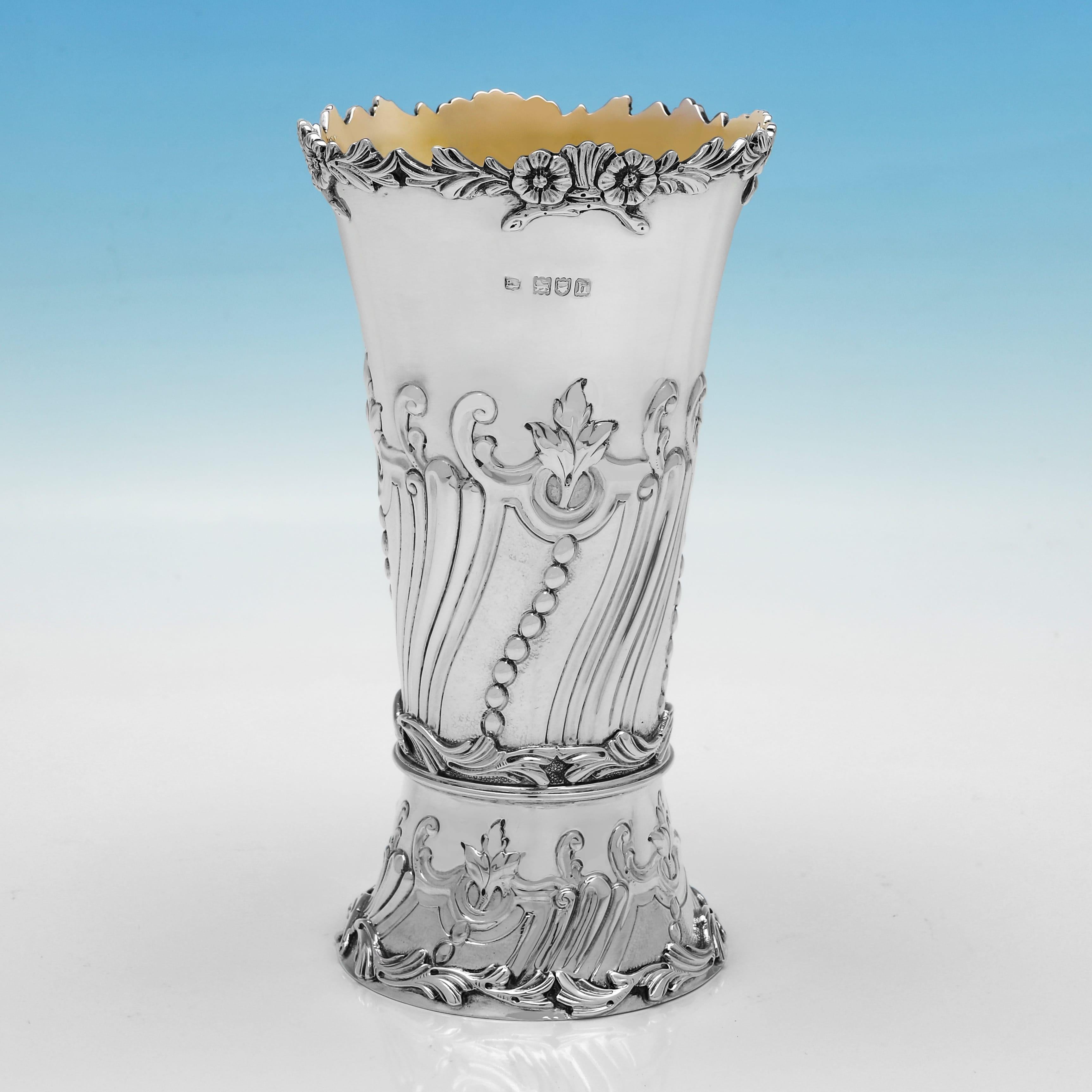 Marchiata a Londra nel 1903 da Lambert & Co., questa attraente coppia di vasi antichi in argento sterling di epoca edoardiana ha uno stile decorativo, con decorazioni cesellate sul corpo, interni dorati e bordi floreali fusi intorno al bordo. Ogni