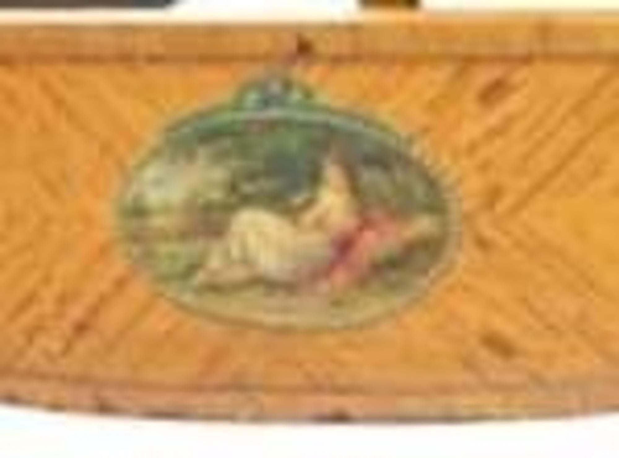 Meuble de chevet en bois satiné doré de l'époque édouardienne,
vers 1905. La tête de lit en arc de cercle est centrée par un médaillon ovale peint d'une jeune fille debout.

Mesures : Longueur 80, largeur 54 pouces.