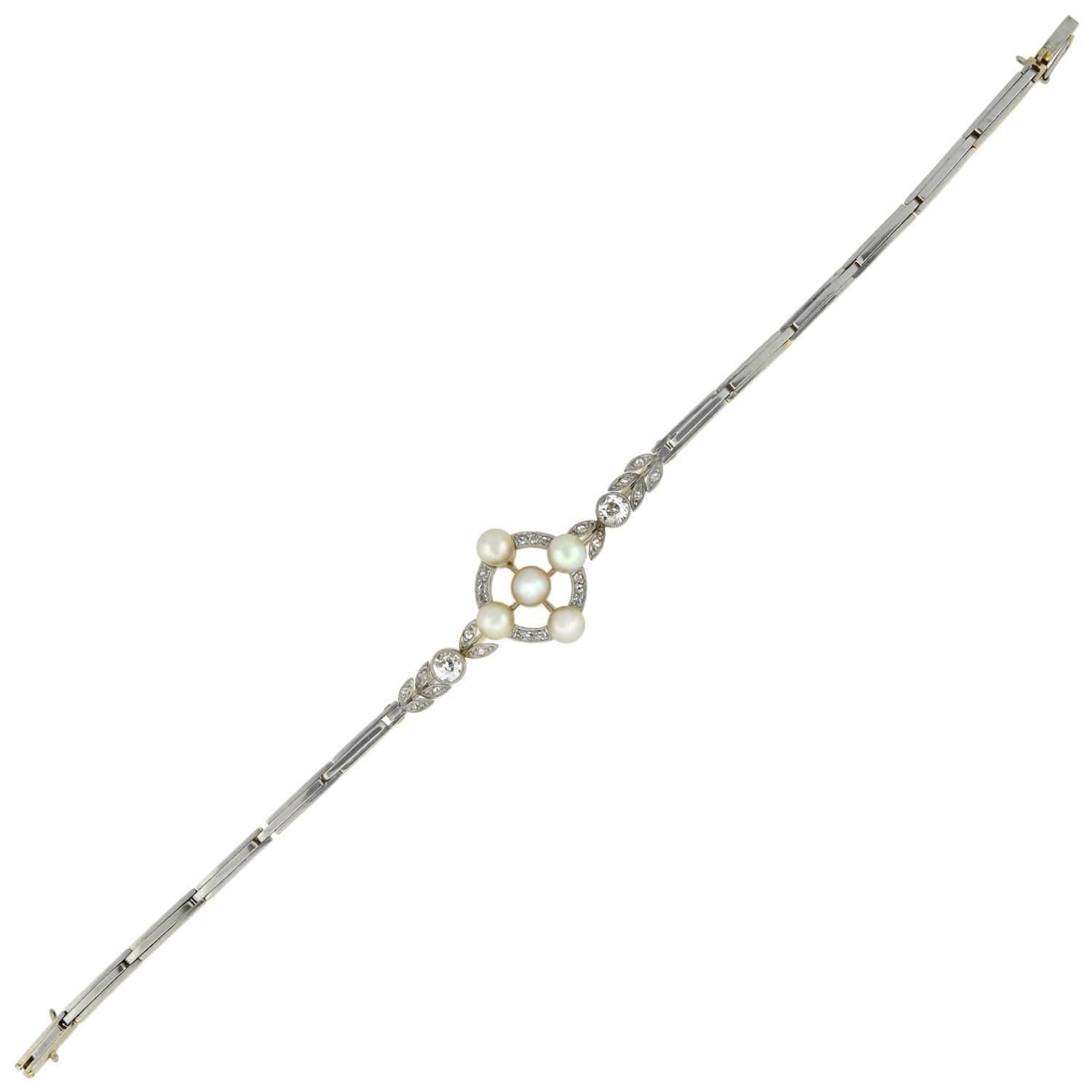 A spectacular pearl and diamond bracelet from the Edwardian (ca1910) era! This stunning platinum topped 18kt yellow gold piece adorns an elaborate design at the center of a simple gate link bracelet. The beautiful centerpiece is formed by a diamond