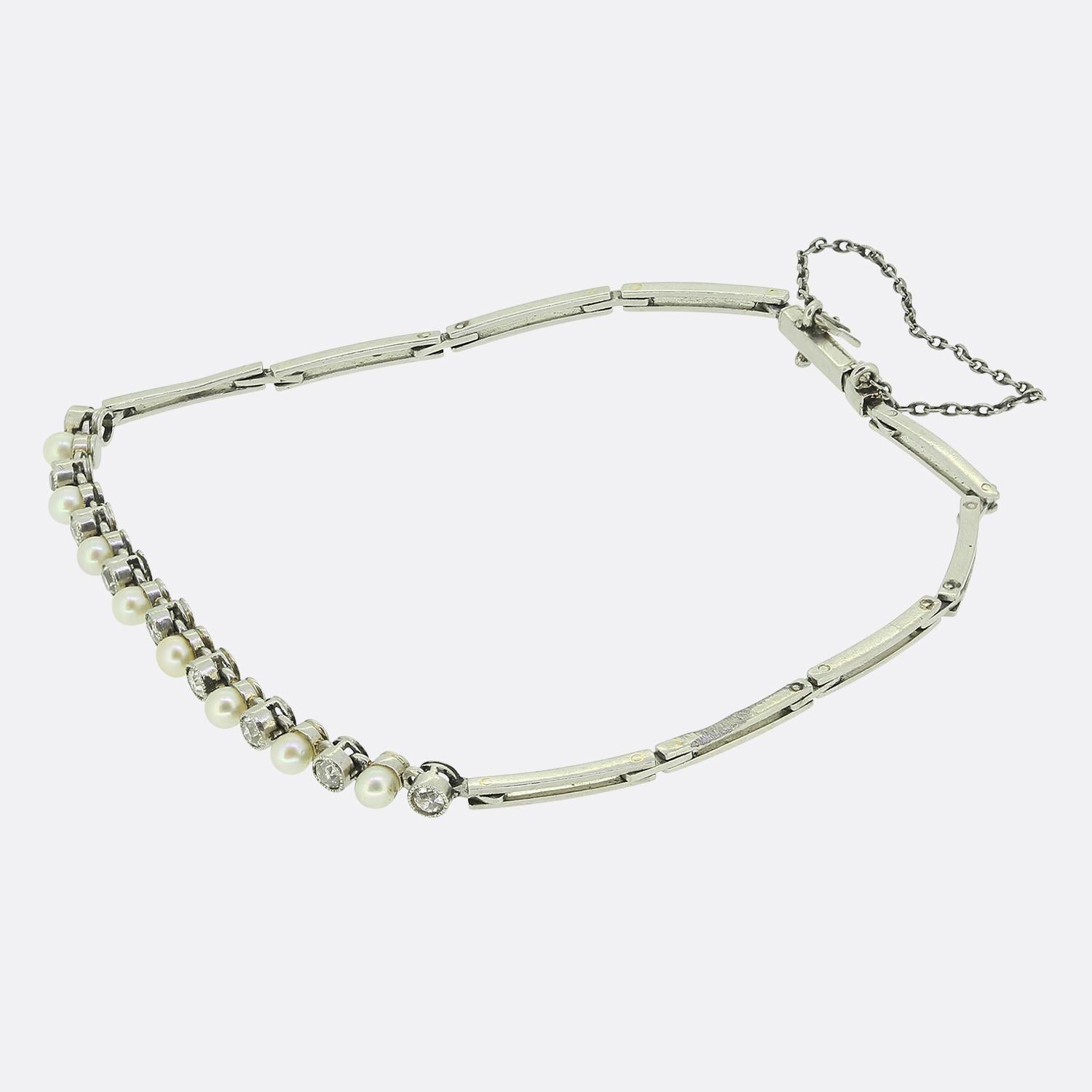 Voici un charmant bracelet au design raffiné, minutieusement réalisé en platine. Cette pièce ancienne, datant de l'époque édouardienne, présente un arrangement harmonieux de perles blanches rondes, entrecoupées de diamants blancs taillés à