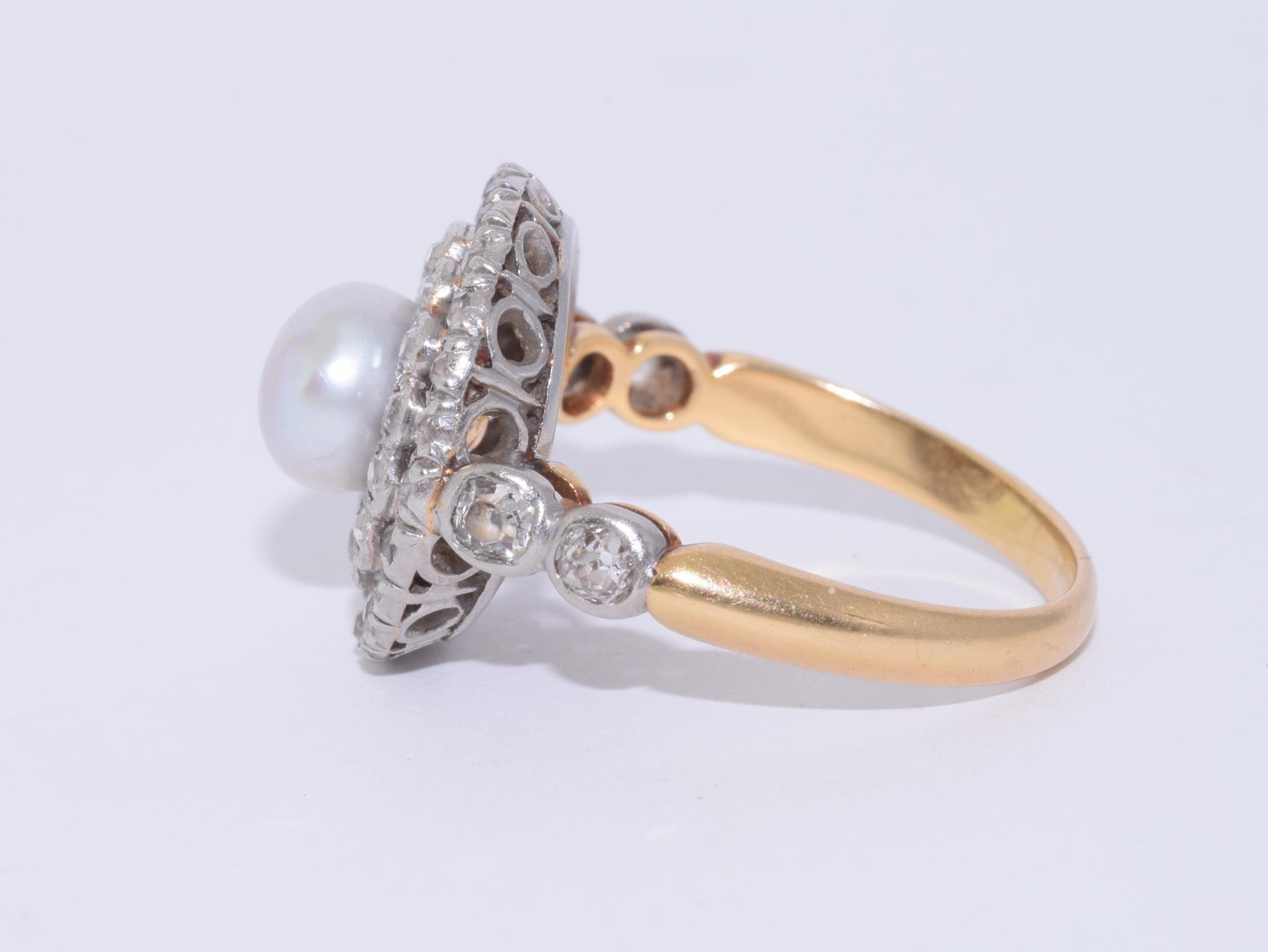 A button pearl measuring approximately 6.5mm is set to the center of a double halo set with old mine diamonds totaling approximately 1.20 carats mounted in platinum topped yellow gold. Circa 1900.

The head of ring measures approximately 15.5mm in