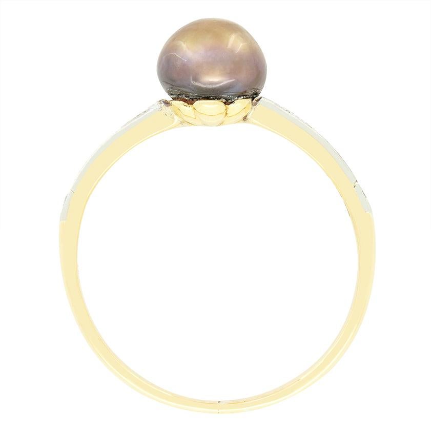 Datant de l'époque édouardienne, cette magnifique bague solitaire s'articule autour d'une seule perle noire. La perle noire est une pierre naturelle de 7 mm de large. Flanquant la perle, un total de 0,24 carat de diamants de taille ancienne descend