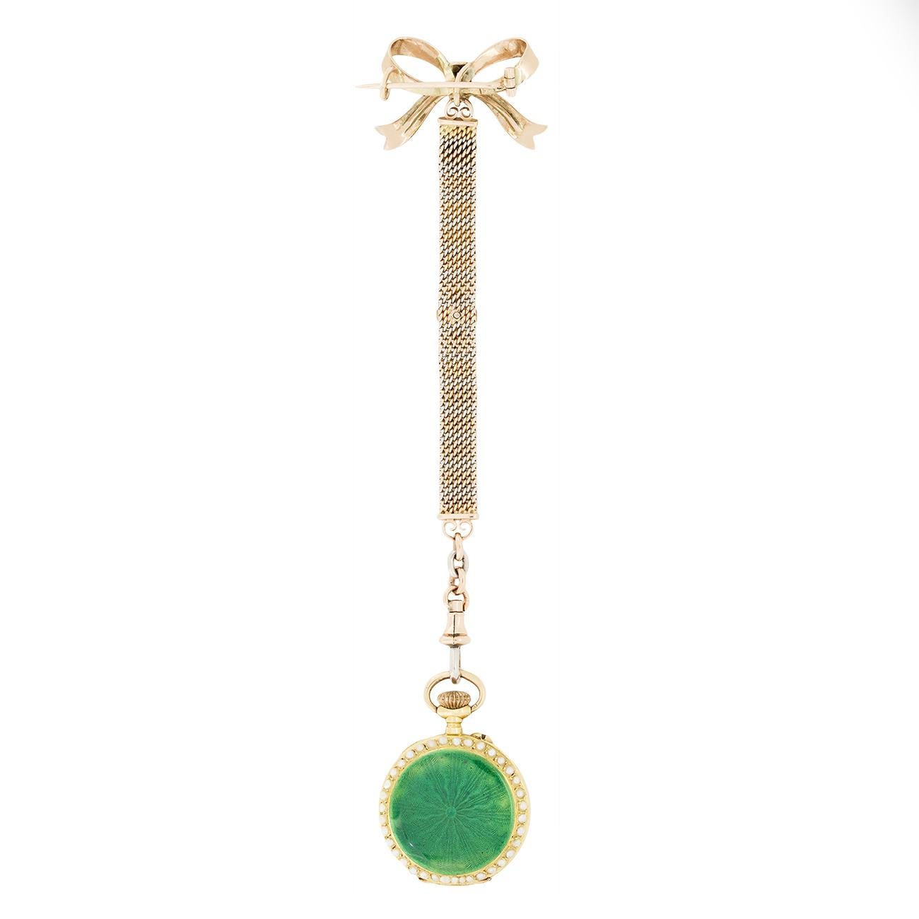 This masterfully crafted pocket watch dates back to the Edwardian era and is truly stunning. A bow of 18 carat yellow gold with green enamel detailing holds the pocket watch in place. A chain crafted from rose gold and platinum elegantly falls to