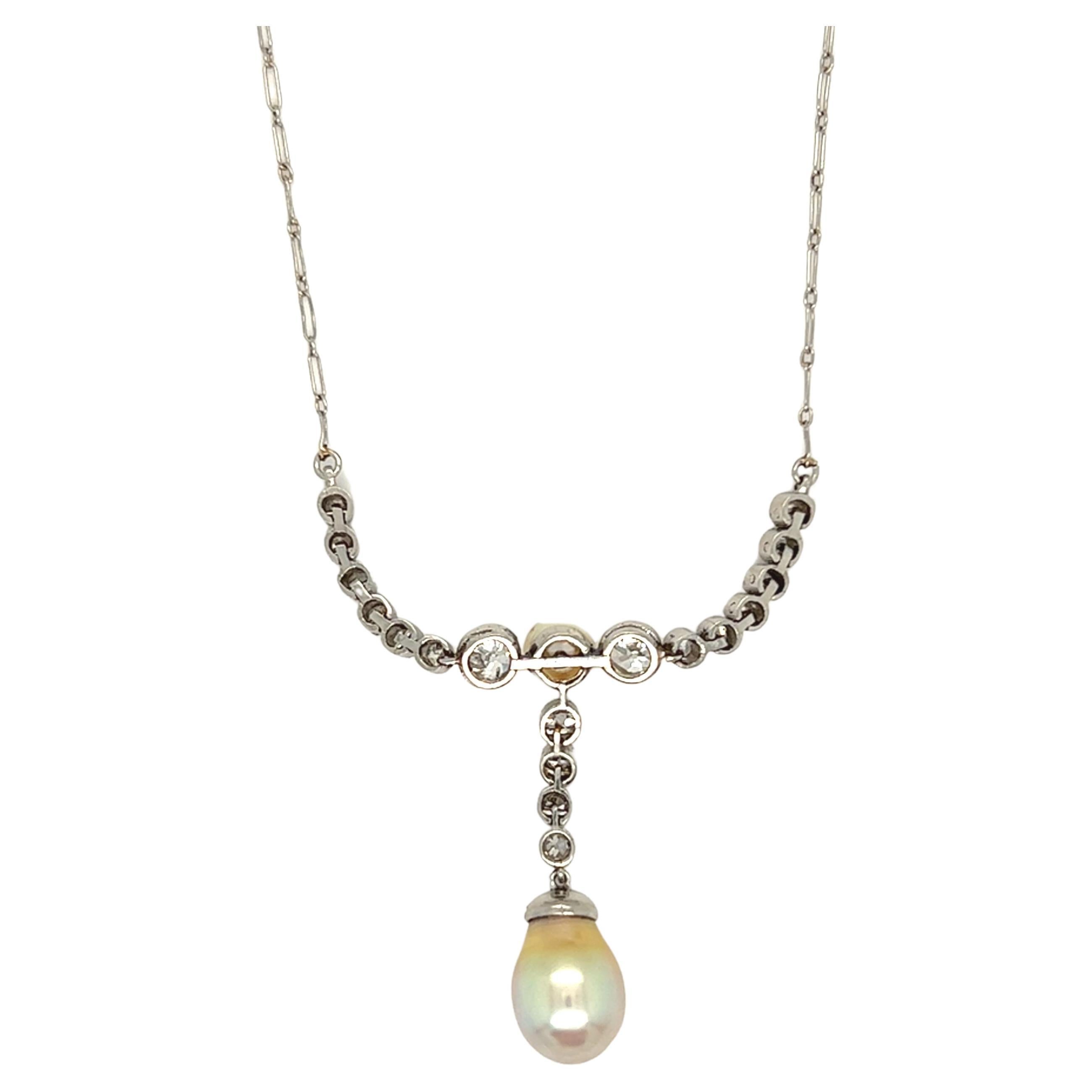 A beautiful Edwardian pearl and diamond necklace features brilliantly white diamonds and two gorgeous pearls in a romantic milgrain detail in Platinum with a delicate platinum chain. It is in immaculate condition. The total weight of diamond is