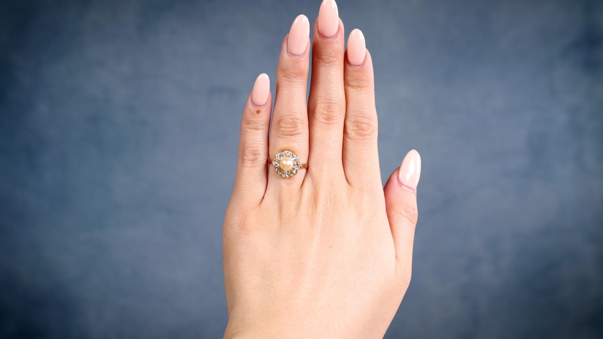 Eine Edwardian Perle Diamant 18k Gelbgold Cluster Ring. Mit einer cremefarbenen Perle von ca. 5.75 mm. Akzentuiert durch acht Diamanten im alten europäischen Schliff mit einem Gesamtgewicht von ca. 0,90 Karat, eingestuft in Farbe J-K, Reinheit