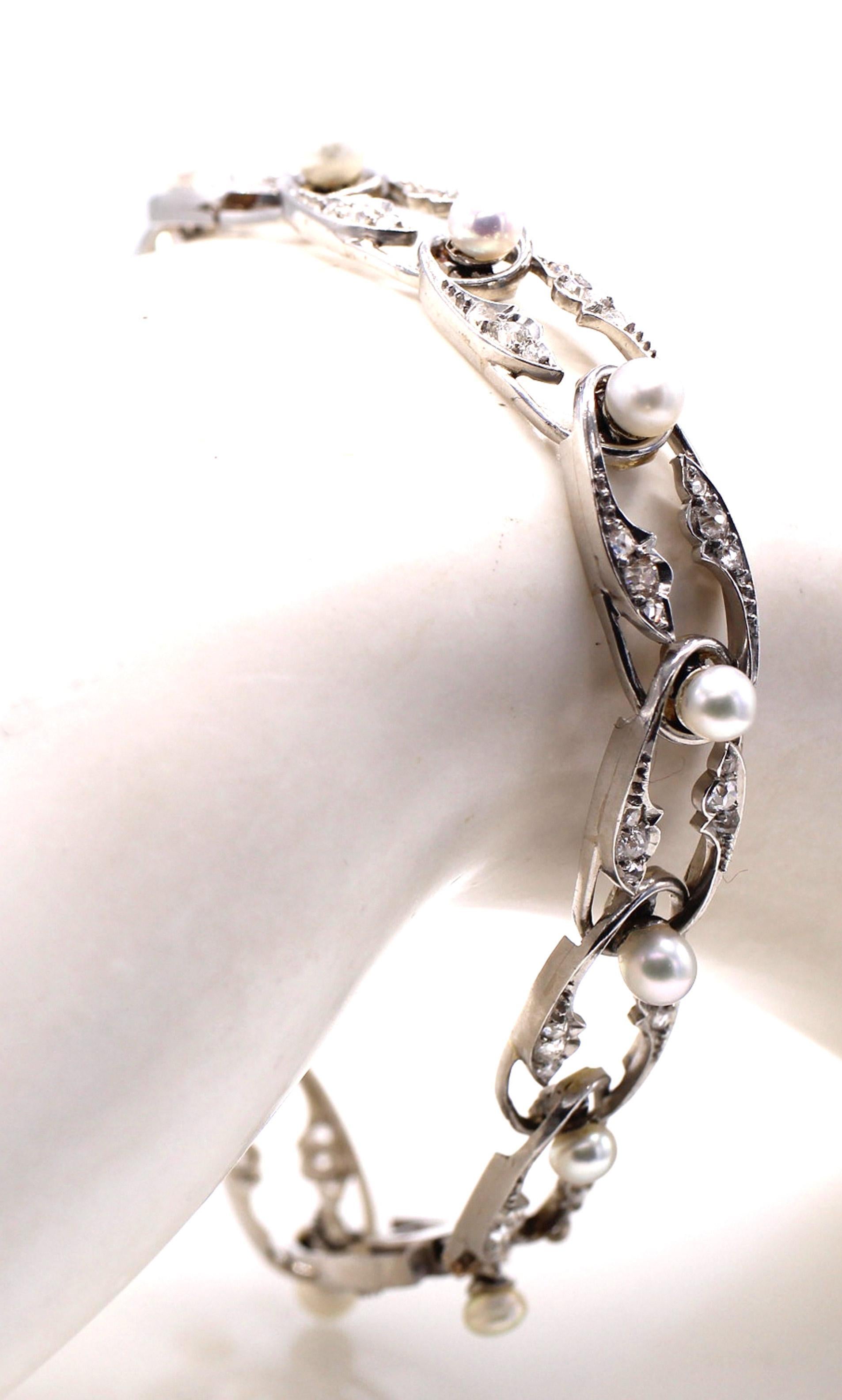 Magnifique bracelet en platine avec diamants et perles, réalisé de main de maître, datant d'environ 1915. 13 maillons ovales et flexibles sont sertis de perles rondes blanches parfaitement assorties, rehaussées de petits diamants taillés à