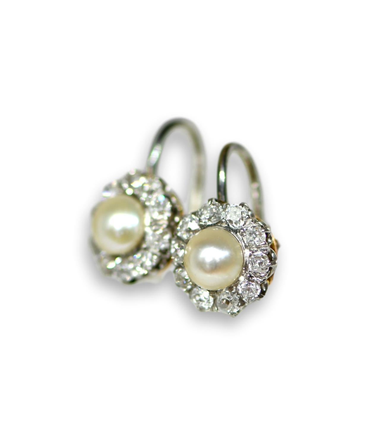 A pair of fabulous French cluster earrings dated in early 20th century. They feature pearls in the centre which has got really beauty luster, each measures 6.5mm. Surrounding are very bright old cut diamonds.These cluster earrings are in great