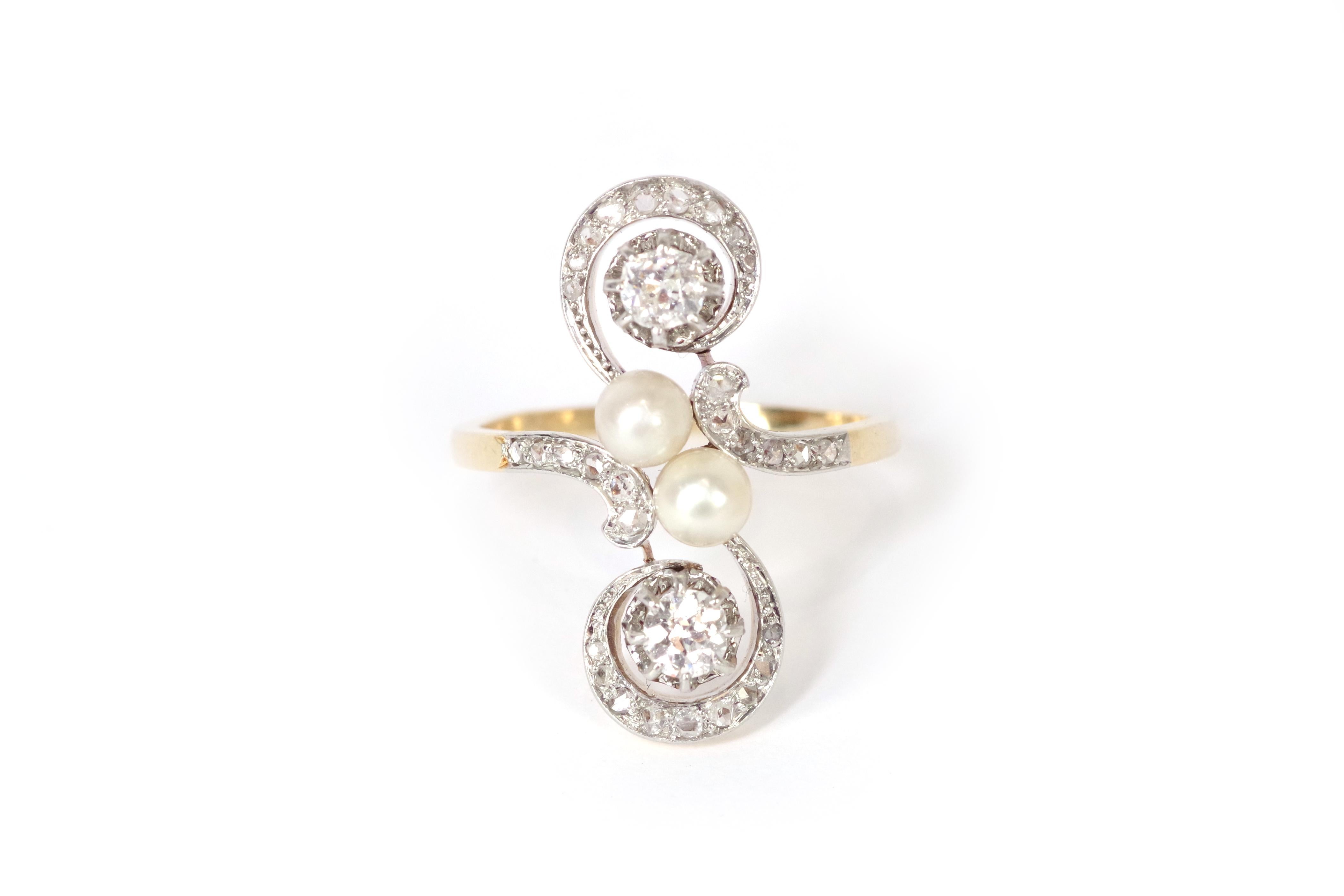 Edwardian pearl diamond ring in 18-karat gold and platinum with pearls and diamonds. This substantial ring features intricate scrollwork, centered with two likely natural pearls arranged in a 