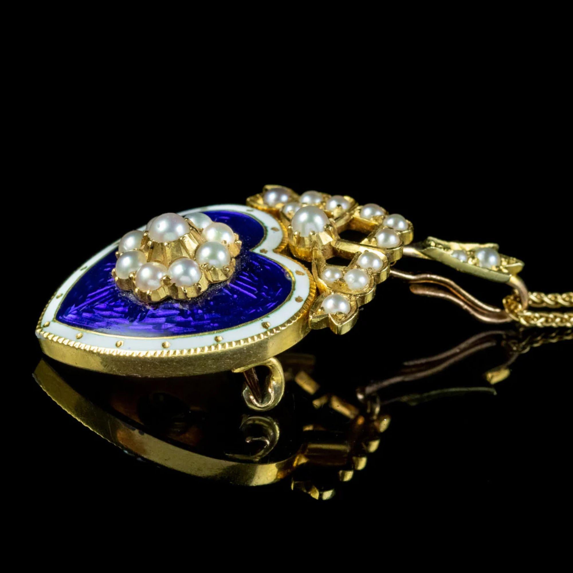 A beautiful antique Edwardian pendant from the turn of the 20th Century depicting a heart, with a pearl flower in the centre and a pearl bow on top. It’s fashioned in 18ct gold and layered in a royal blue, guilloche enamel with a white border.