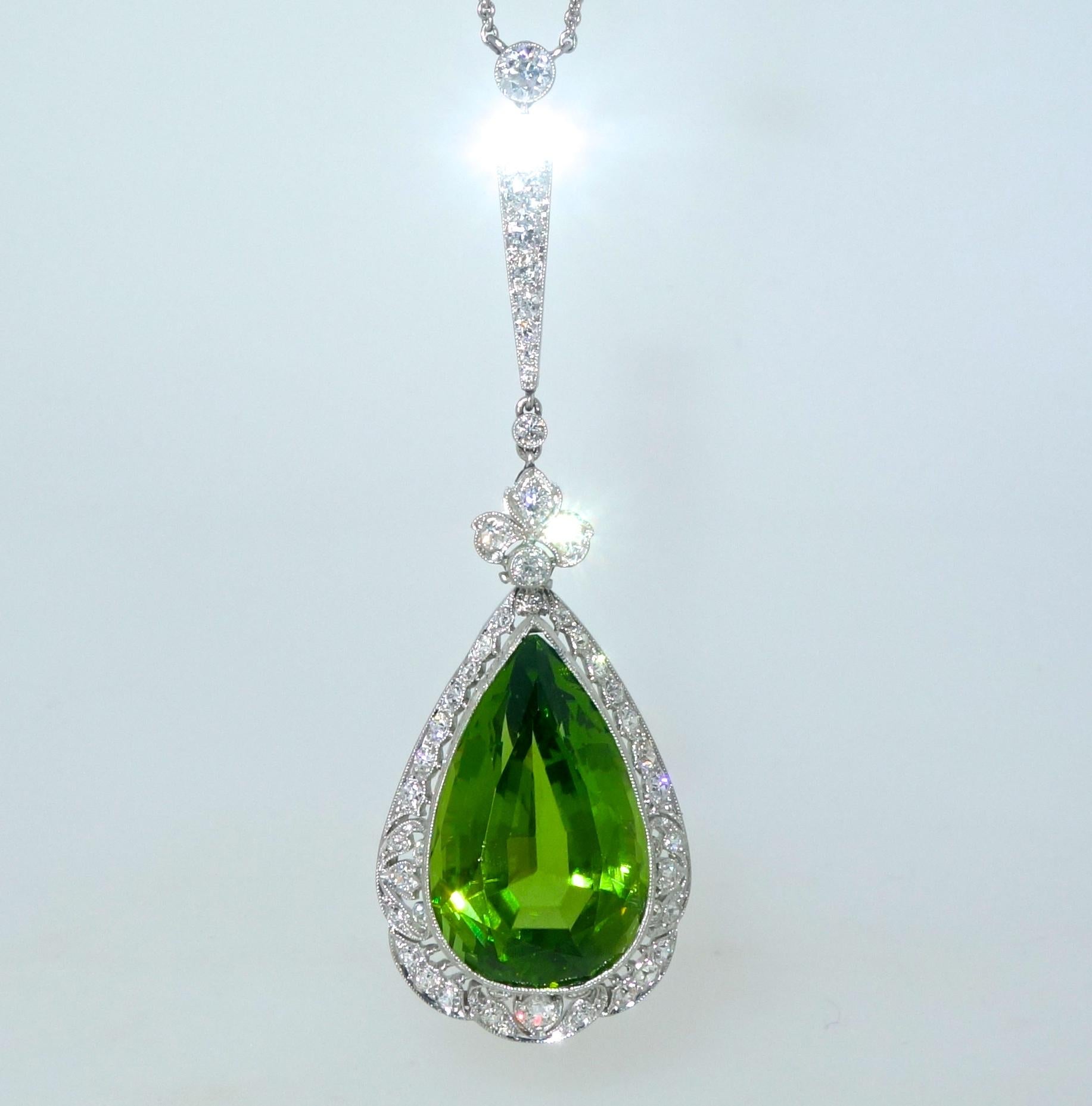 Edwardian pendant necklace centering a fine natural bright green peridot weighing approximately 19.5 cts.  Surrounding this pear cut stone are numerous European cut diamonds weighing approximately 1.6 cts.  This hand made platinum piece shows