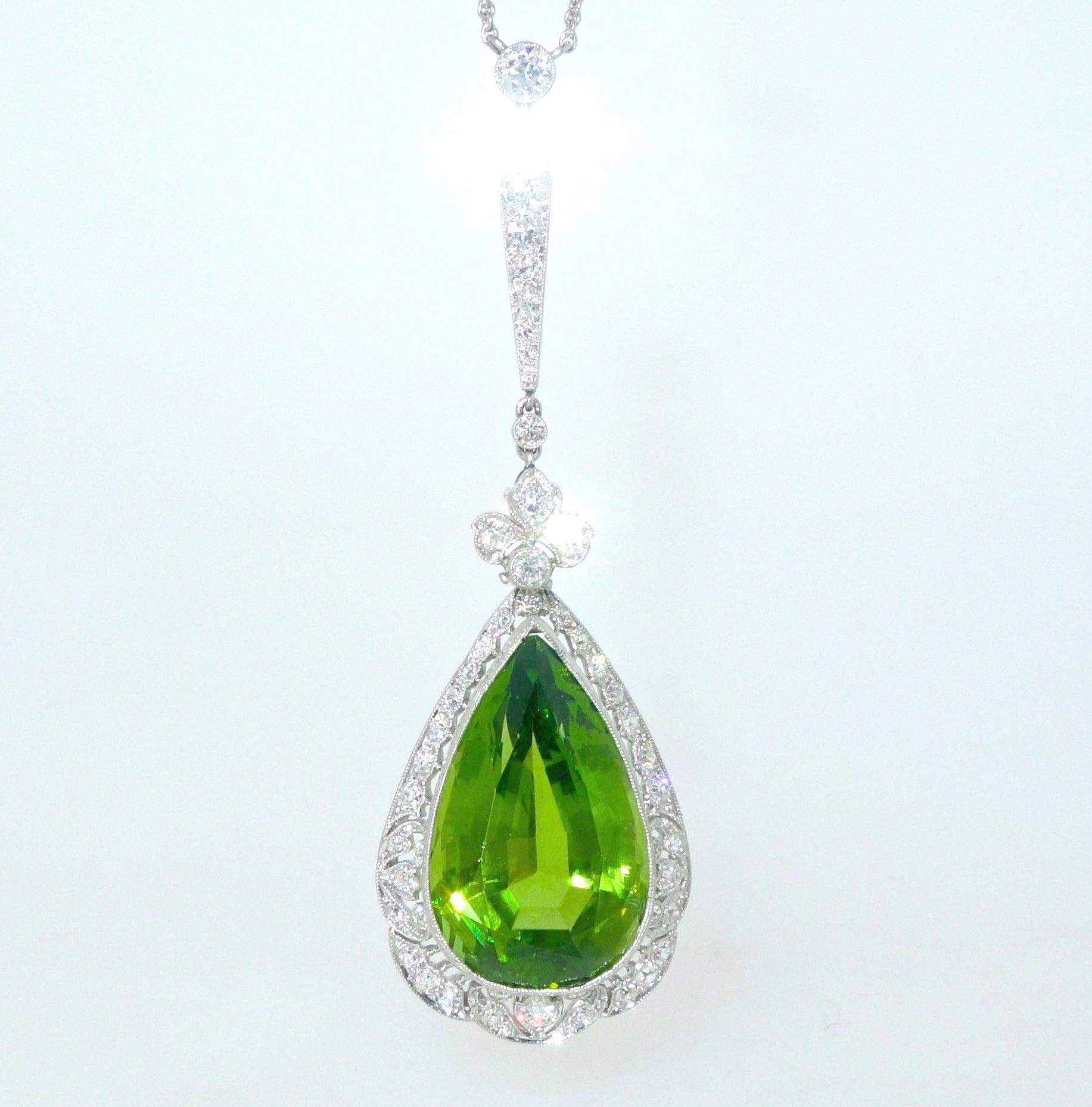 Edwardian pendant necklace centering a fine natural bright green peridot weighing approximately 19.5 cts.  Surrounding this pear cut stone are numerous European cut diamonds weighing approximately 1.6 cts.  This hand made platinum piece shows