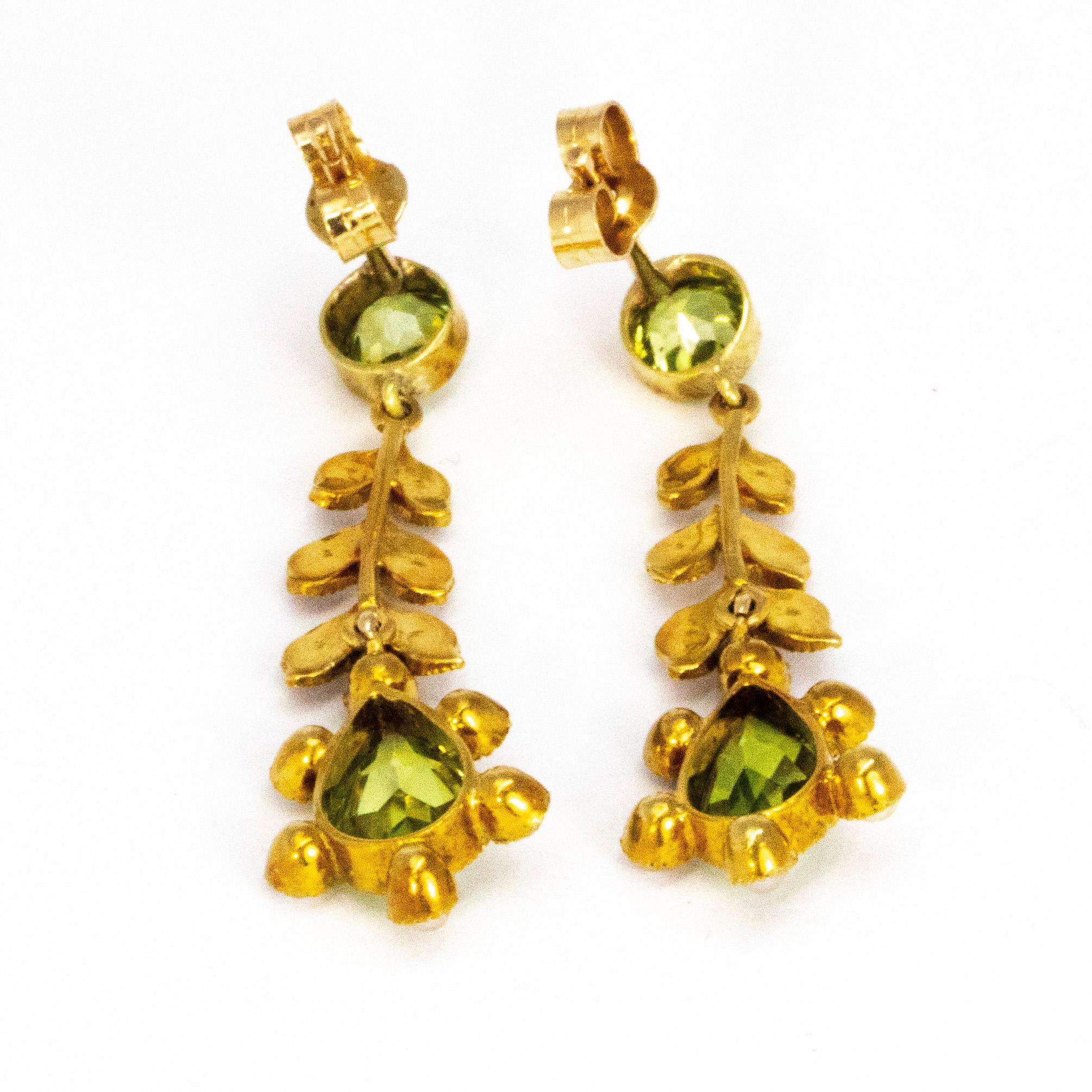 These stunning earrings hold a 1ct tear drop and 40pt round cut peridot along with seed pearl detail on the leaf shaped drops. The stones are all held in yellow gold and are stud earrings. 

Drop Length: 33.5mm 