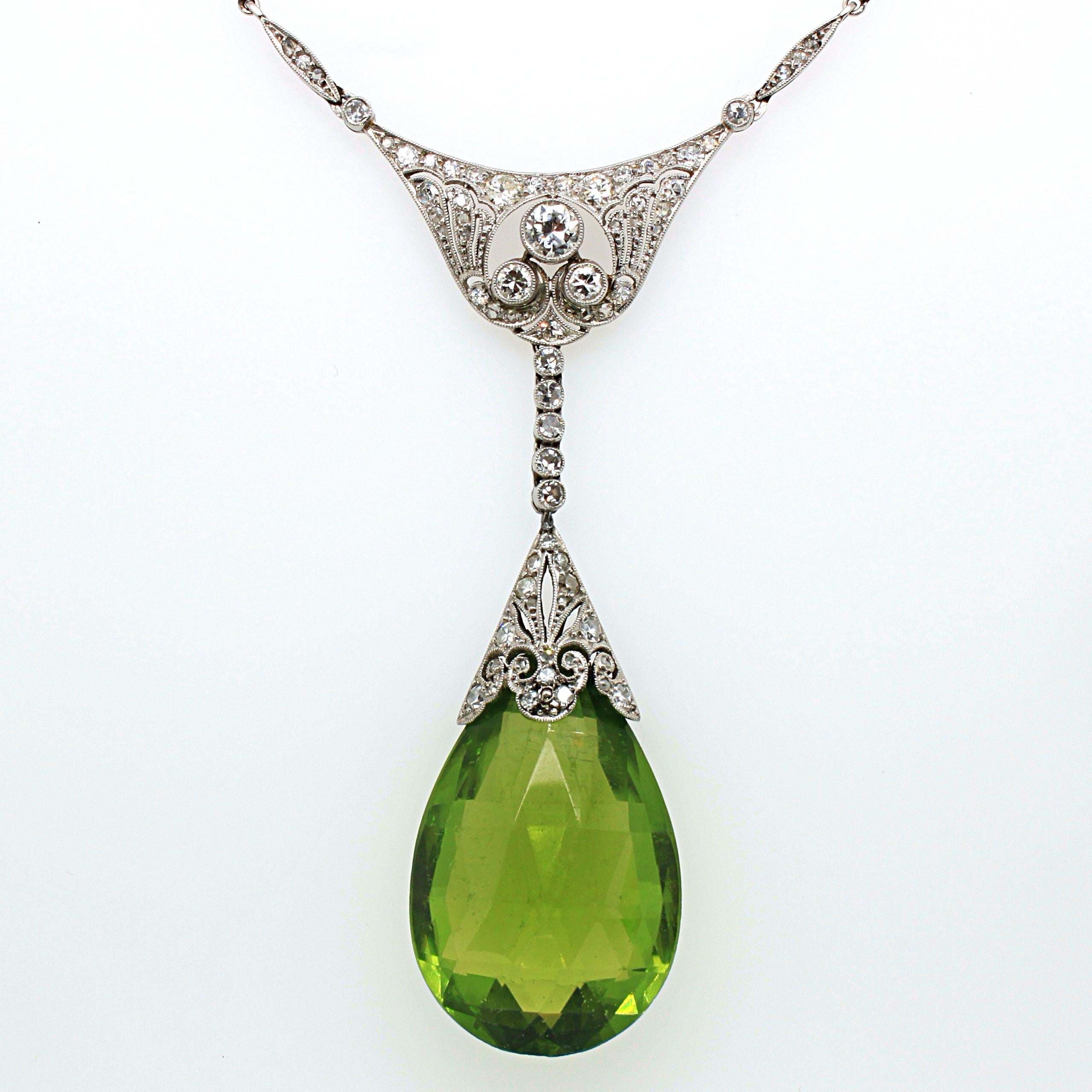 An Edwardian peridot briolette and diamond necklace in platinum, ca. 1910s. The Burmese peridot has a very tranquil and harmonious green colour, yet displays a beautiful crystal with a strong intensity. It weighs approximately 30 carats and has no