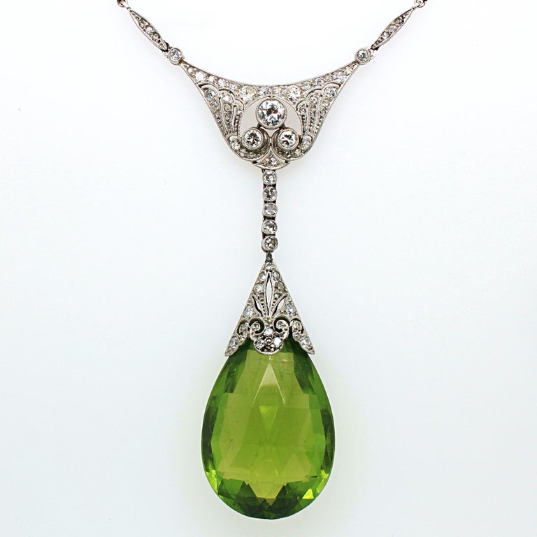 An Edwardian peridot briolette and diamond necklace in platinum, ca. 1910s. The Burmese peridot has a very tranquil and harmonious green colour, yet displays a beautiful crystal with a strong intensity. It weighs approximately 30 carats and has no