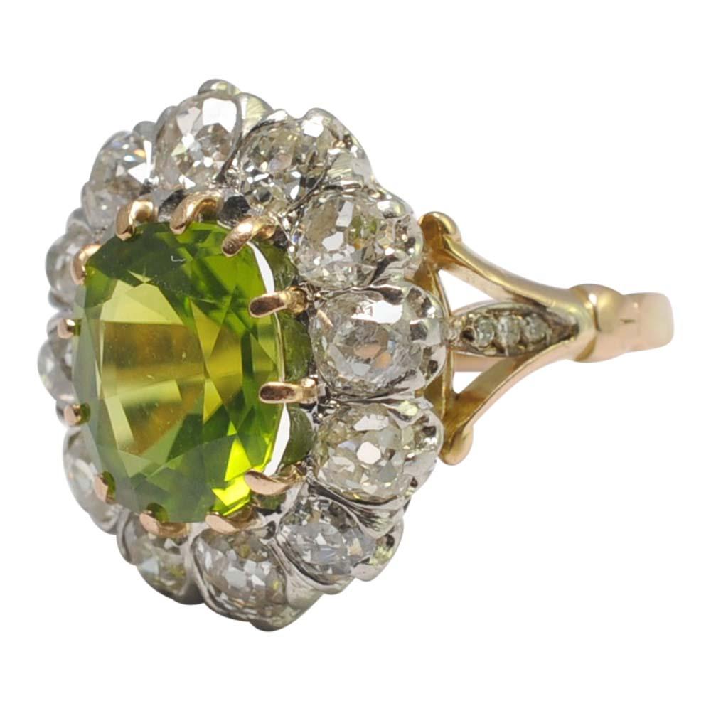 Antique Edwardian peridot and diamond cluster ring in 18ct gold.  This is a dramatic and beautiful ring from the late Edwardian era that really makes a statement.  The peridot is a rich lime green colour, weighs 4.30ct and is surrounded by chunky