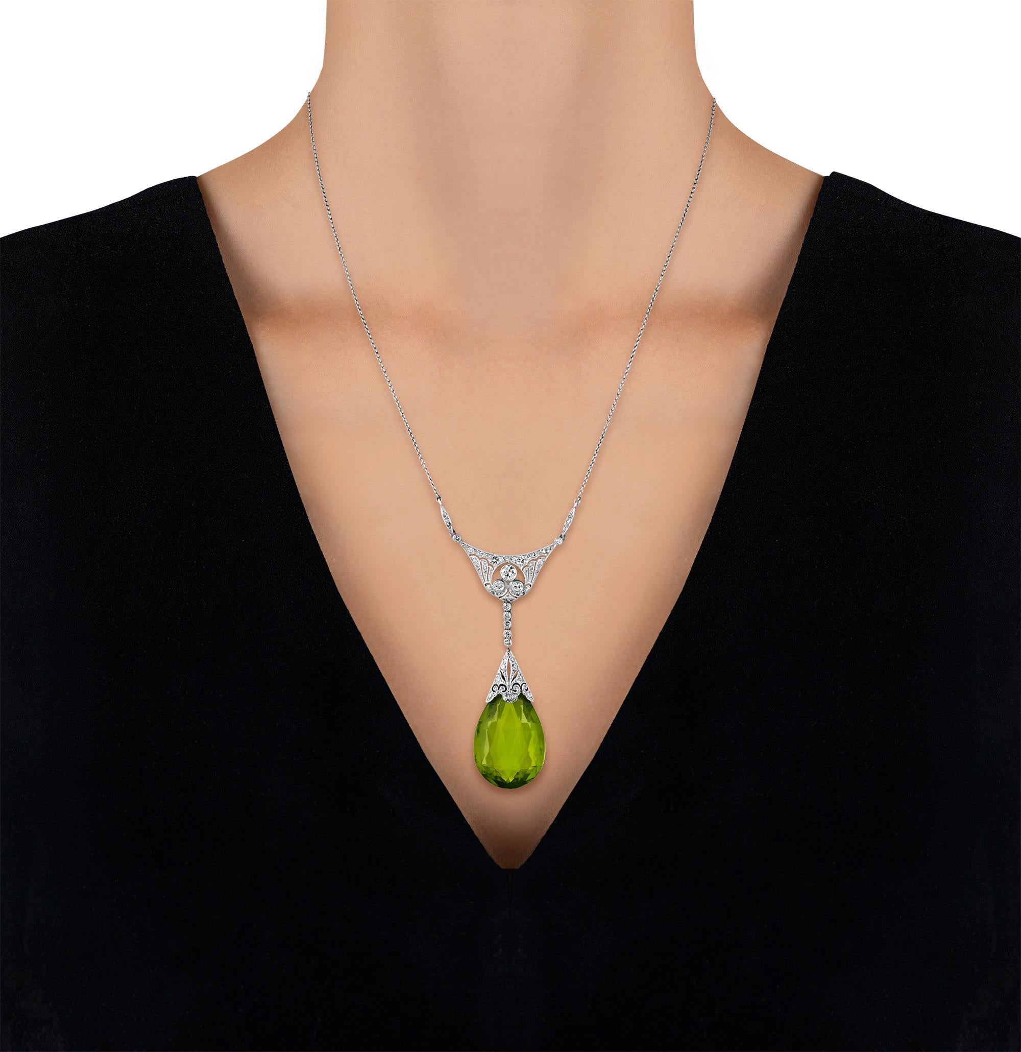 Dieses Collier aus der Edwardianischen Ära präsentiert einen exquisiten Peridot im Briolett-Schliff mit einem Gewicht von 30,00 Karat, der sich durch seine außergewöhnliche Klarheit und Brillanz auszeichnet. Der leuchtend grüne Edelstein hängt