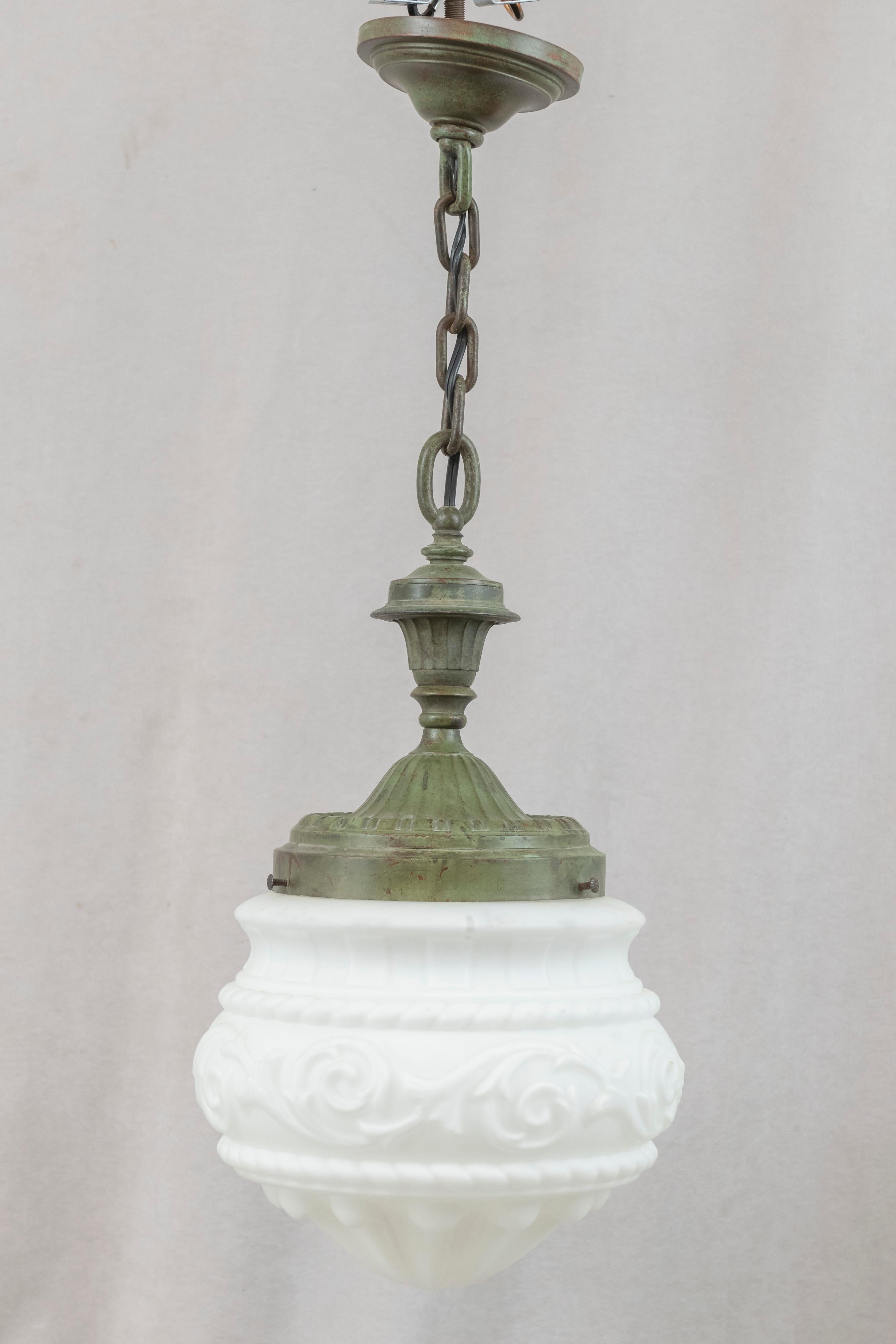 This handsome pendant is the perfect light for an entryway, hallway, or even the kitchen. The bronze metalwork was done by the noted foundry Bradley & Hubbard, and bears their signature in the ceiling canopy. Having that soft green patina on the