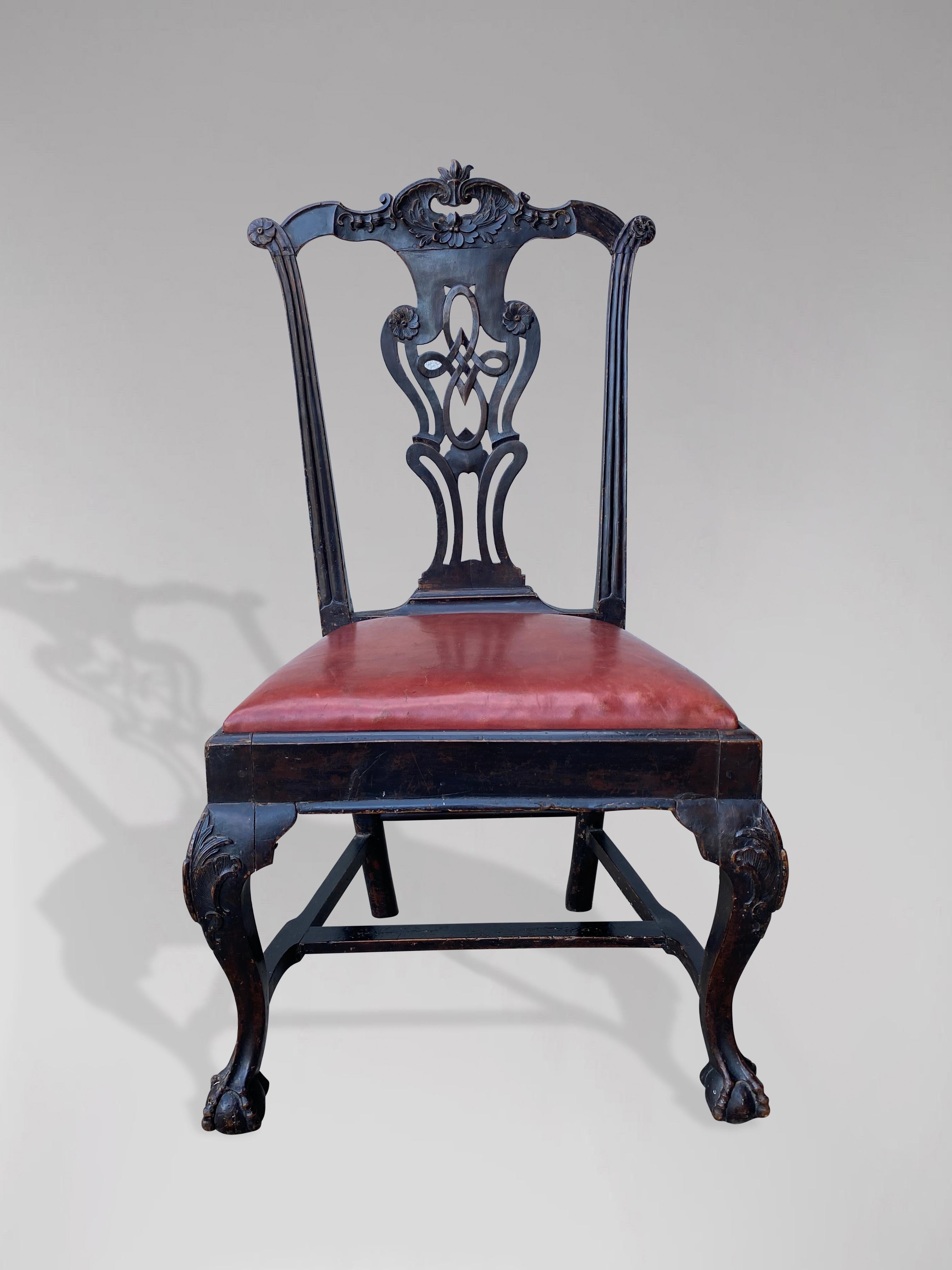 Ein bemalter und geschnitzter Einzelstuhl aus dem frühen 20. Jahrhundert in der Chippendale-Manier. Mit serpentinenförmiger Kammleiste und durchbrochener Rückenleiste mit geschnitzten Ornamenten. Der Stuhl ist originallackiert und hat einen