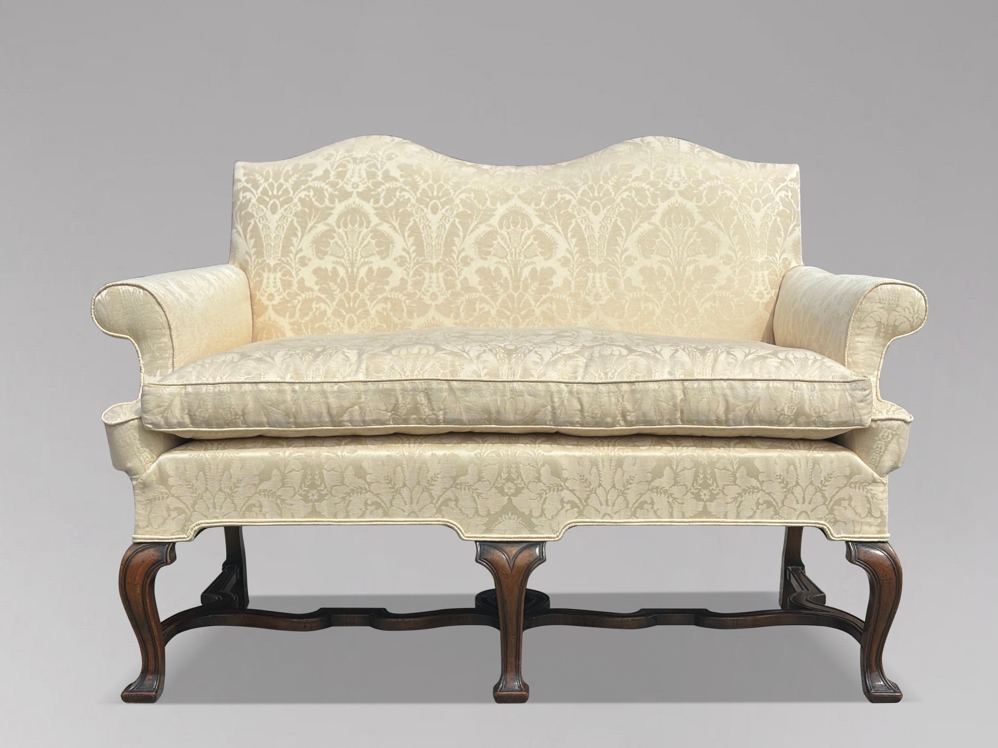 Fine Edwardian Period Carved Walnut Settee of Queen Anne Style 

This elegant carved walnut settee or love seat embodies the classic Queen Anne style from the early 20th century. It features a charming double-hump back and scroll-over arms,