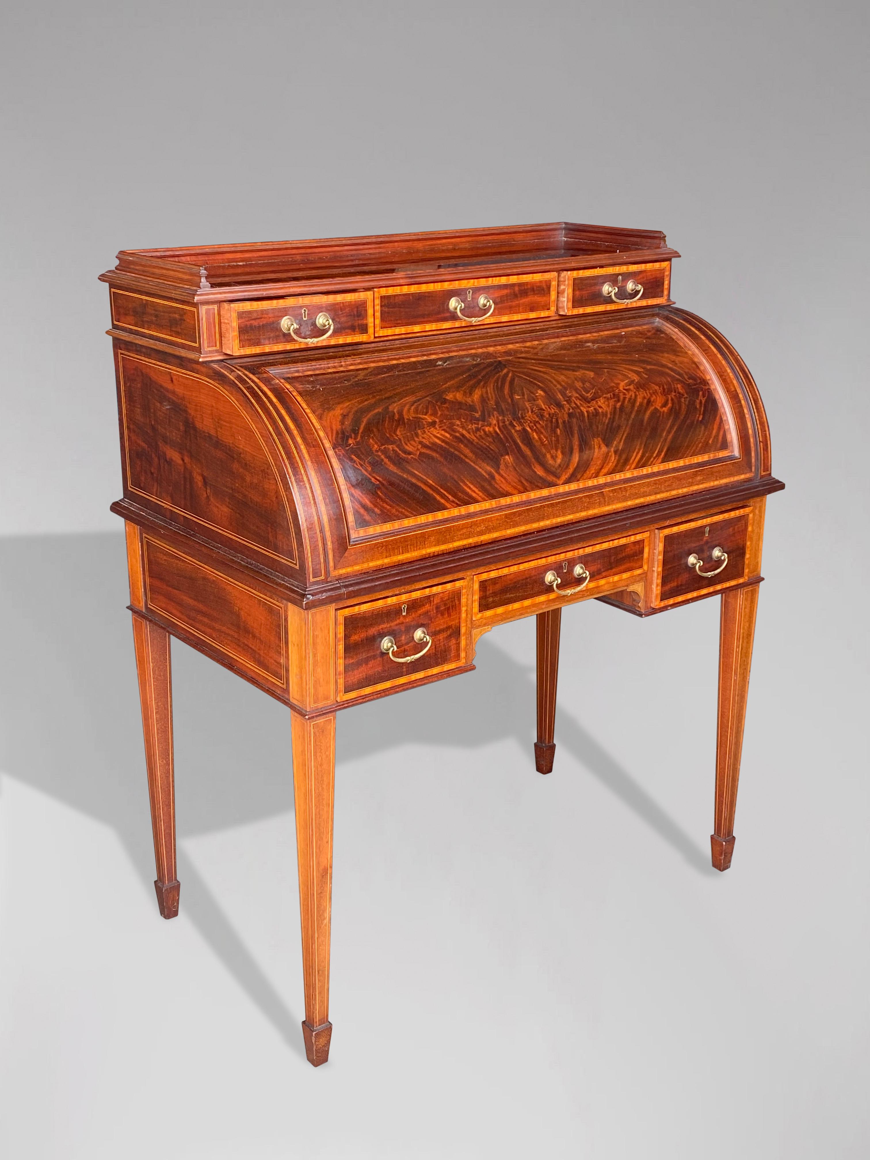 A stunning quality, early 20th century, Edwardian period mahogany free standing roll top desk from the renown London makers MAPLE & CO. Inlaid throughout with satinwood banding, boxwood and ebony stringing with good quality mahogany linings. The