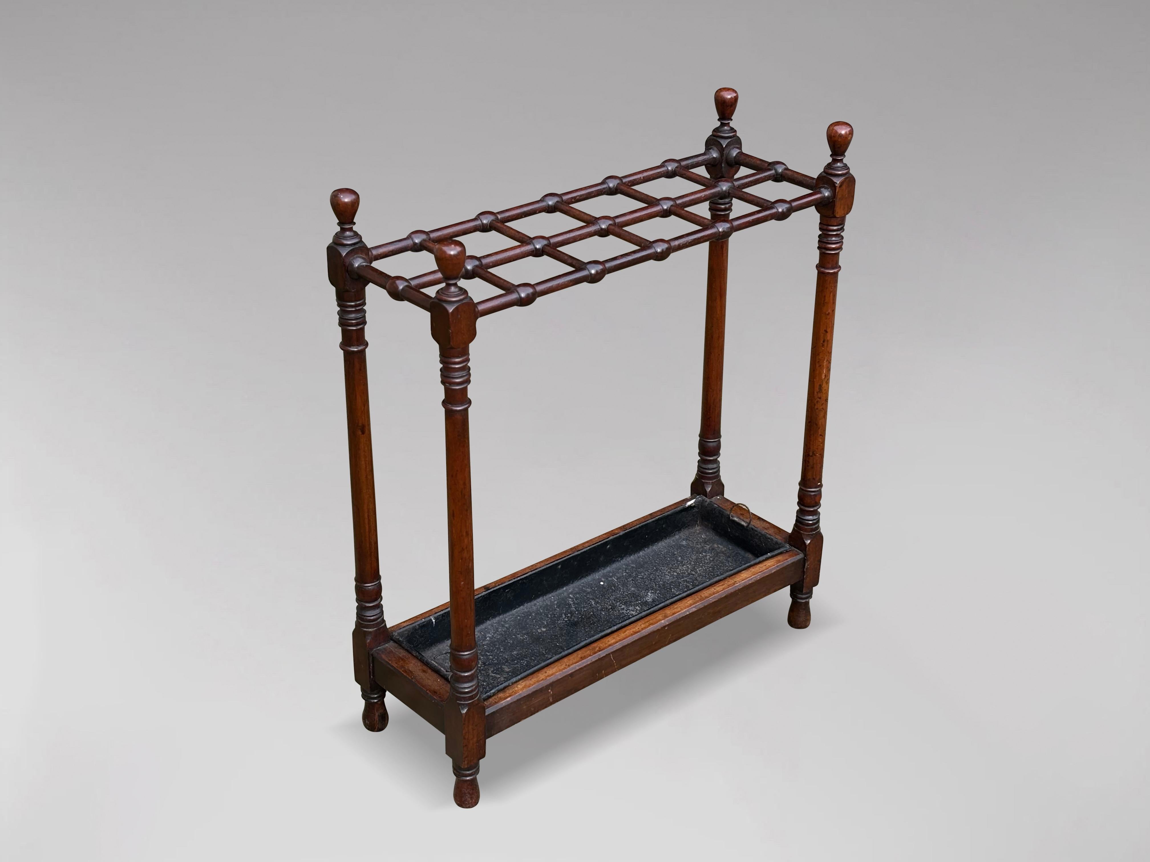 Very fine early 20th century, Edwardian period free standing mahogany hall stick, umbrella stand made from solid mahogany. The top with twelve segments, supported by turned baluster columns with finials, base with removable compartment tin drip